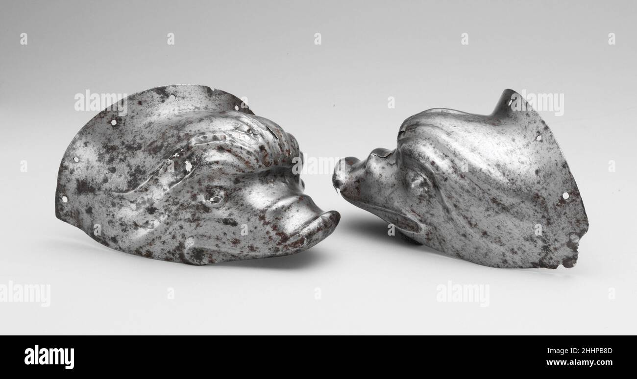 Paar Ohrenschützer von einem Shaffron (Kopfverteidigung des Pferdes) ca. 1525–30 Deutsche, wahrscheinlich Augsburger, die in der Sammlung des Museums lange übersehen wurden, sind diese ungewöhnlichen Ohrenschützer außergewöhnlich in der Form stilisierter Delfine. Jeder Delphin wird in hohem Relief aus einer Stilplatte mit einem nach außen gedrehten Flansch an der Basis geschmiedet, der mit einer Reihe von Nietlöchern durchbohrt wird, durch die er am Shaffron befestigt wurde. Jeder Delphin hat eine knollige, gerollte Stirn mit Graten, die sich auf beiden Seiten des Gesichts erstrecken; Augen; eine gerippte Schnauze mit aufgedrehtem Ende; und einen Mund. Bei der Montage hätte jeder von ihnen upw gegenübergestellt Stockfoto