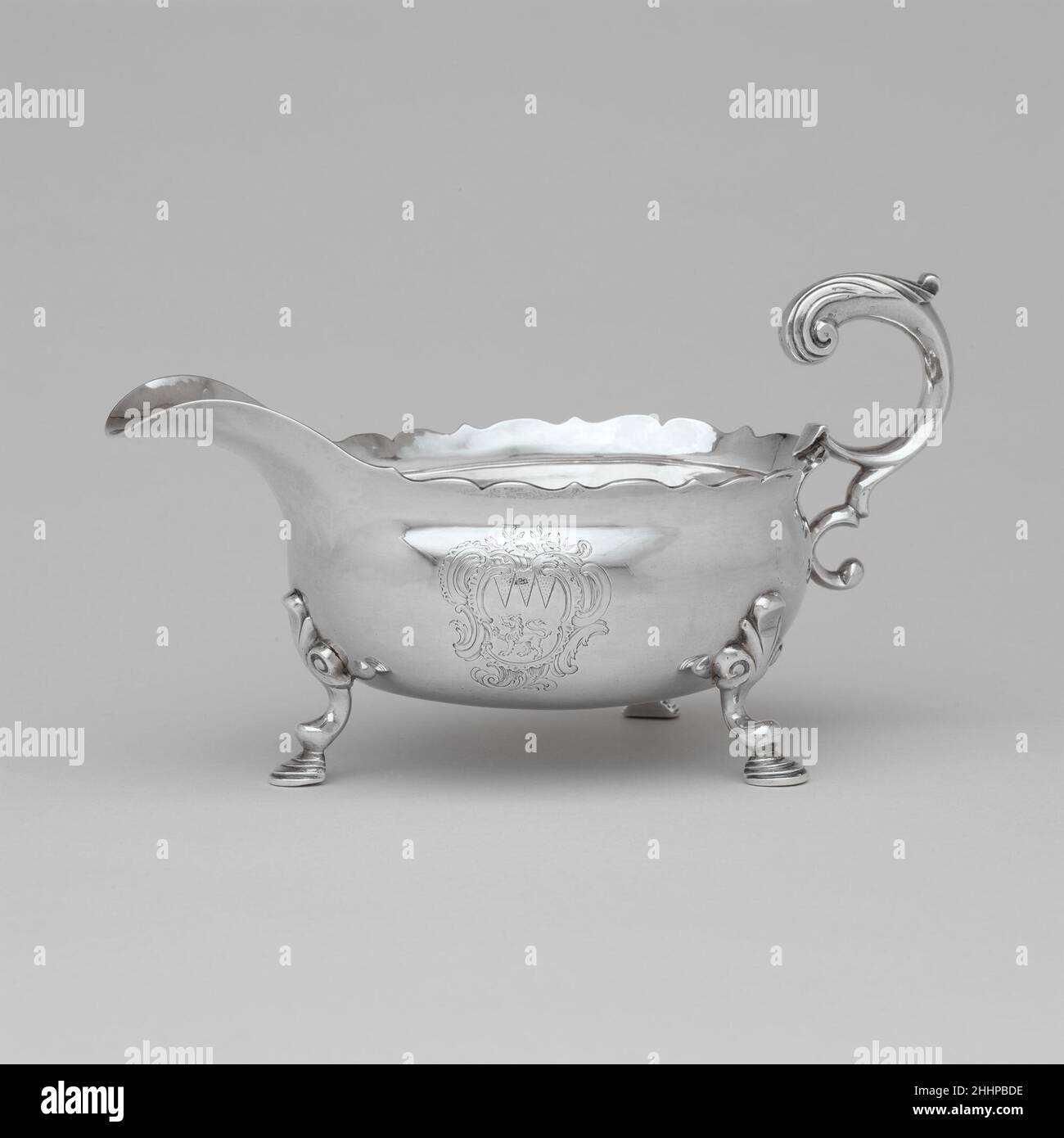 Sauceboat 1750–55 Joseph Richardson Sr. In der ersten Hälfte des 18. Jahrhunderts in Amerika eingeführt, folgten silberne Sauceboats dem Design zeitgenössischer englischer Schiffe, mit gerollten Griffen und breiten, ausgießenden Lippen, die oft auf drei Gussfüßen getragen wurden. Dieses Sauceboat und sein Partner (24.109.27) tragen das Zeichen von Joseph Richardson Sr., einem der bedeutendsten Silberschmiede aus dem 18. Jahrhundert in Philadelphia und Mitglied einer bedeutenden Handwerkerdynastie. Sie sind mit den Armen von Logan in einer Rokoko-Kartusche eingraviert. Obwohl die Provenienz nicht dokumentiert ist, kombinieren die Wappen-Gravur Stockfoto