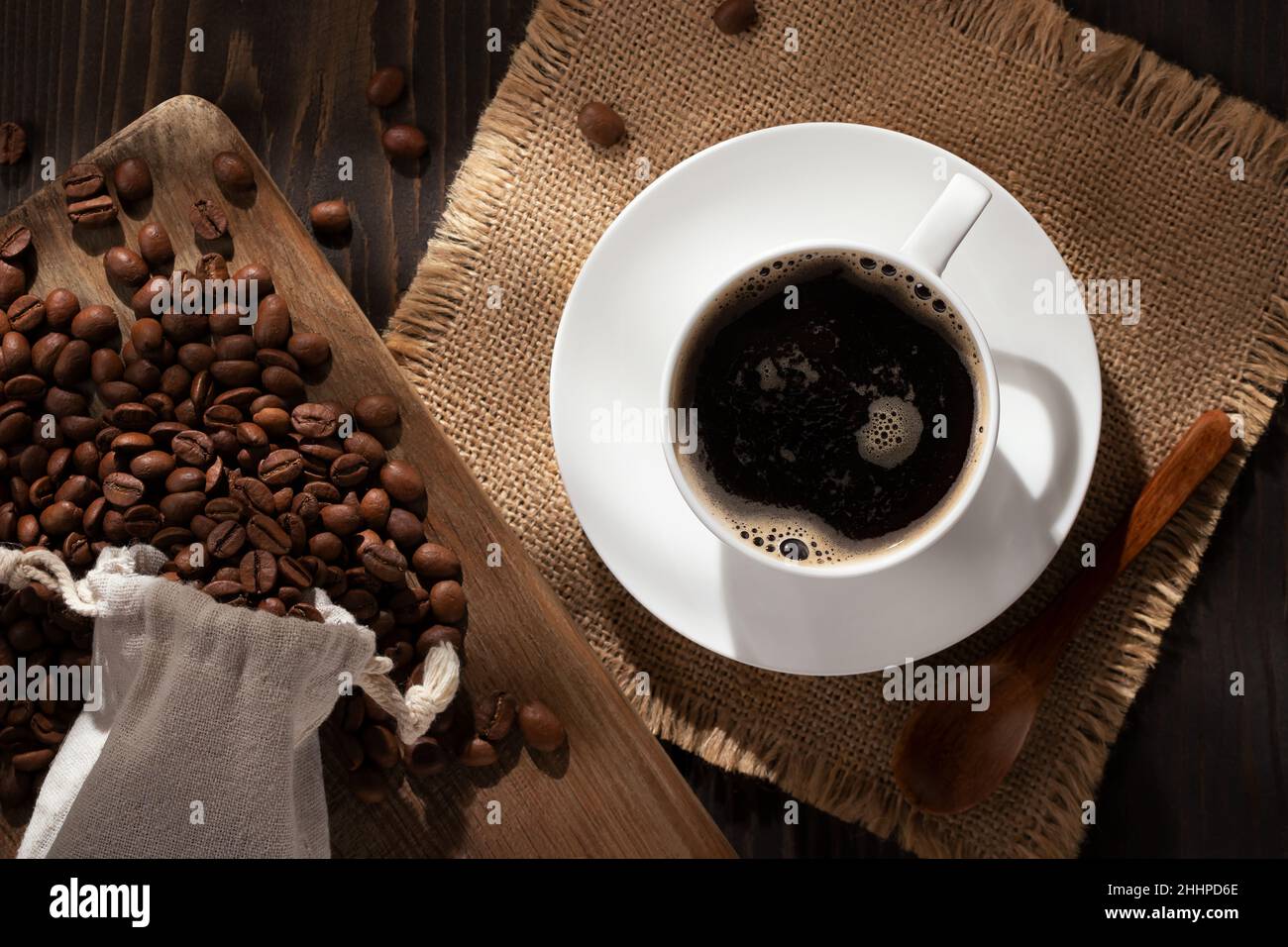 Weiße Tasse frischen heißen Kaffee und Kaffeebohnen auf dem Tisch, topview, flat lay. Stockfoto