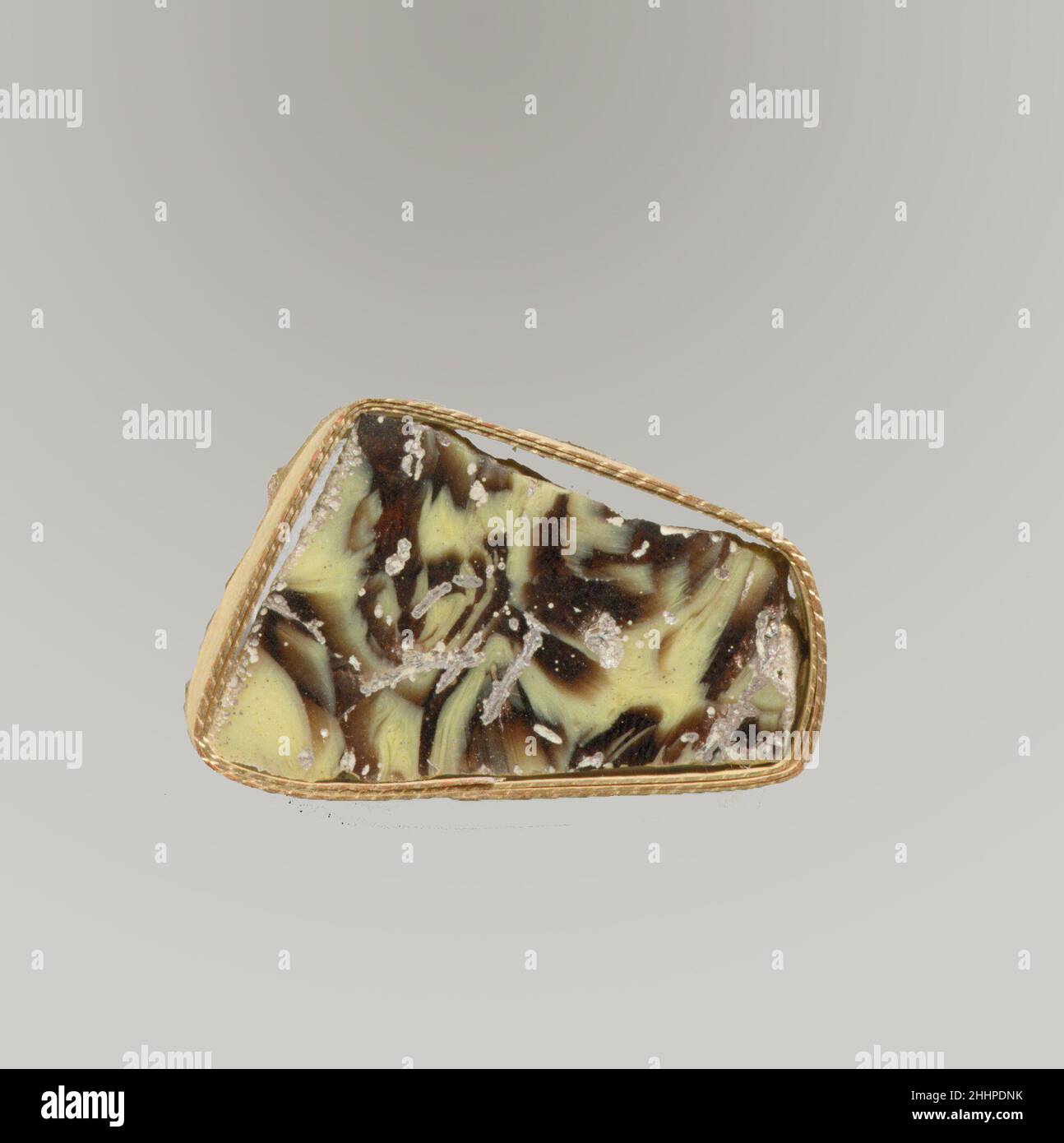 Glasmosaik-Inlay Fragment Ende 1st. Jh. v. Chr.–Anfang 1st. Jh. n. Chr. Römisches Fragment von Revetment-Plakette.Durchscheinendes Lila und opakes Gelb.Flachinlay, mit einem geraden abgeschrägten Rand; Unterseite leicht uneben und zum Rand hin dünner.Marmoriertes Mosaikmuster in purpurem Boden mit unregelmäßigen gelben Linien und Streifen.Polierte Oberseite; Lochfraß von Oberflächenblasen, mit einigen Oberflächenrissen; Lochfraß und schillernde Verwitterung an Unterseite und Kanten. Glasmosaik-Inlay-Fragment. Römisch. Spätes 1st Jahrhundert B.C.–frühes 1st Jahrhundert A.D.. Glas; Guss. Frühkaiserlich. Glas Stockfoto