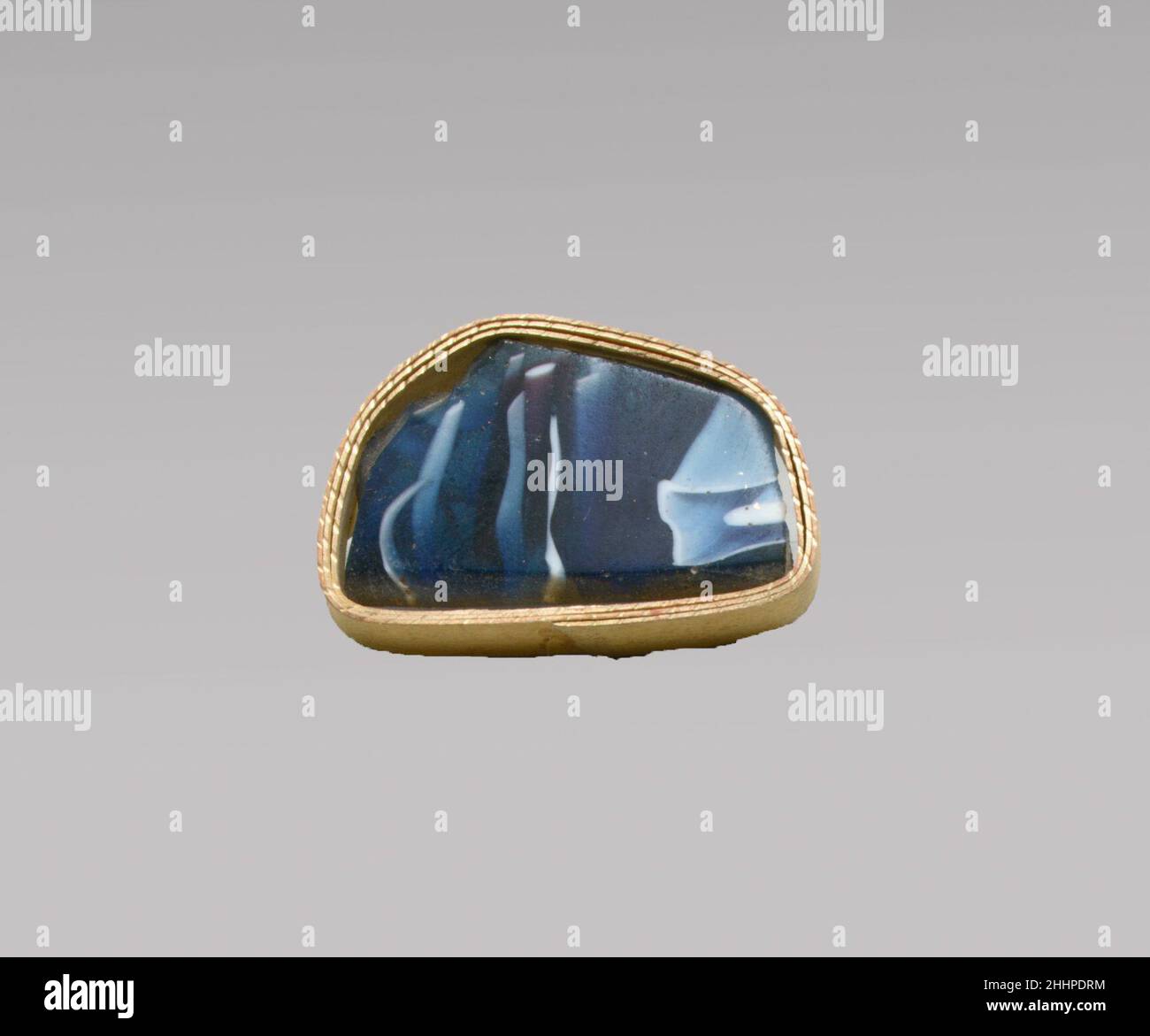 Glasmosaik-Schalenfragment Ende des 1st. Jahrhunderts v. Chr.–Anfang des 1st. Jahrhunderts n. Chr. römischer Rand Fragment einer großen Schale oder Schale.Durchscheinendes Kobaltblau und opakes Weiß.Abfackelrand mit abgeschrägter Lippe; gewölbte Seite im Inneren.Mosaikmuster aus zwei Teilen: Eine auf blauem Grund mit unregelmäßig welligen weißen Fäden und Streifen in parallelen Linien, die andere auf blauem Grund mit einem zentralen weißen Stab, der von einem weißen Quadrat umgeben ist.Polierte Außenseite; leichtes Lochfraß von Oberflächenblasen an der Außenseite; stumpfende und cremig schillernde Verwitterung an Innen-, Rand- und gezackten Kanten. Horizontales Grindi Stockfoto