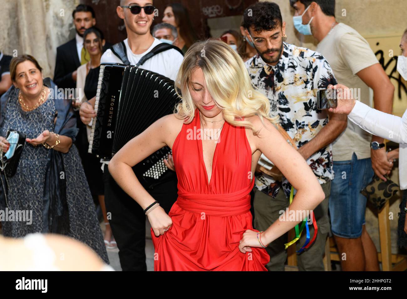 LECCE, ITALIEN - 19. AUGUST 2021, Frau in rotem Kleid tanzen barfuß apulischen Volkstanz nennen pizzica oder taranta auf der Sommerstraße von Lecce und peop Stockfoto