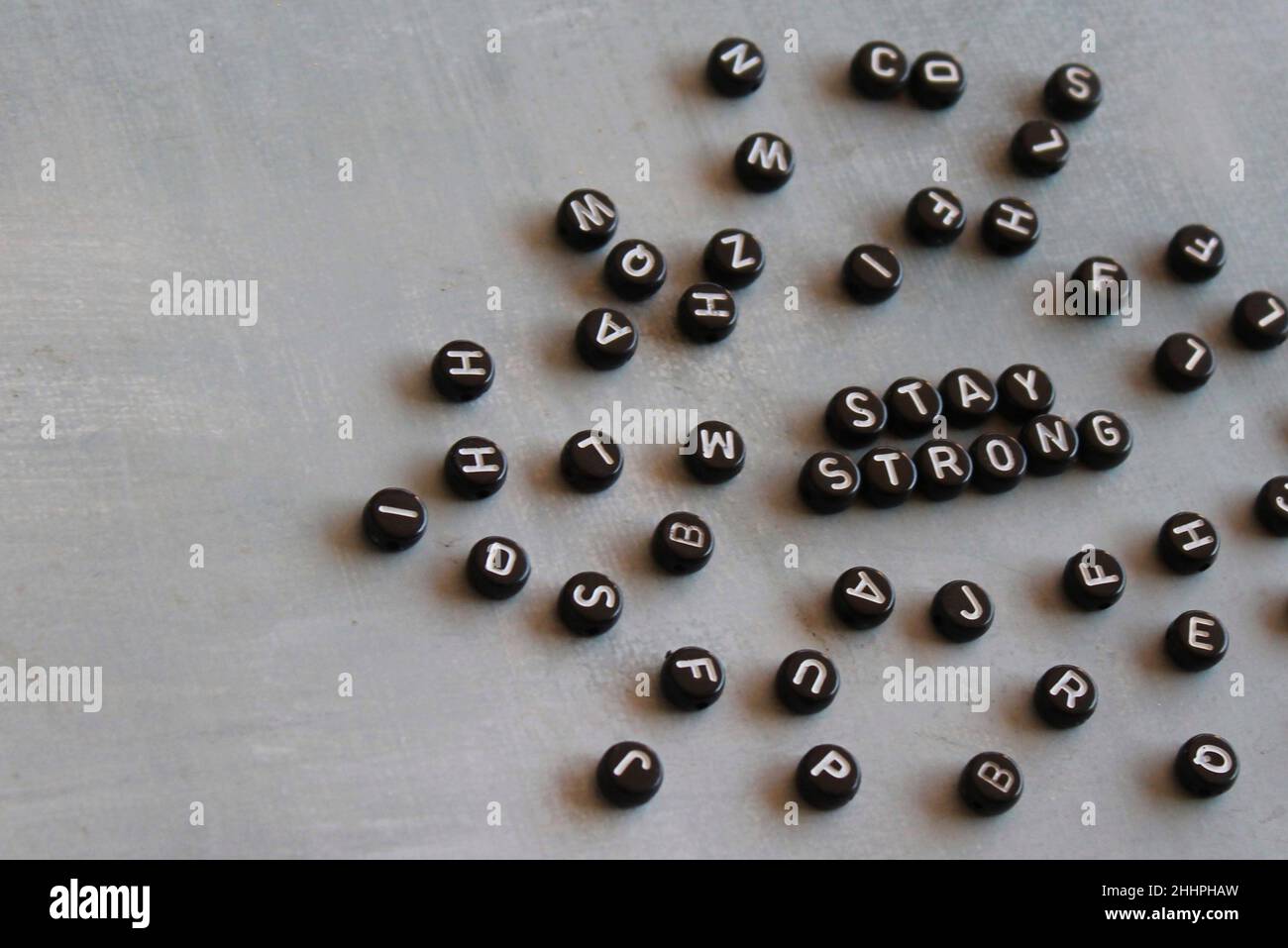 Selektives Fokusbild von Alphabetisphären mit Text BLEIBT AUF Betonboden stabil. Stockfoto