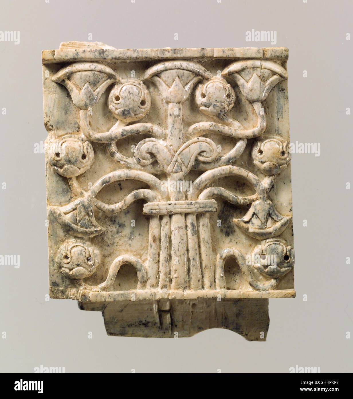 Möbelplatte in Relief mit stilisiertem Baum geschnitzt Ca. 8th.–7th. Jahrhundert v. Chr. Assyrisch Diese Tafel wurde in einem Lagerraum in Fort Shalmaneser, einem königlichen Gebäude in Nimrud, gefunden, in dem Beute und Tribut aufbewahrt wurden, die von den Assyrern während des Militärfeldzuges gesammelt wurden. Es zeigt einen stilisierten Baum, der fächerartige Papyrus-Blüten und stilisierte abgerundete Blüten kombiniert, die Granatäpfel darstellen können. Aus einem zentralen Stamm strahlt ein zartes Netz von elf Zweigen aus, das in der Mitte durch ein horizontales Element zusammengebunden ist; oben entspringt ein Paar gewellter, blattähnlicher Formen, genannt Voluten, aus dem Stockfoto