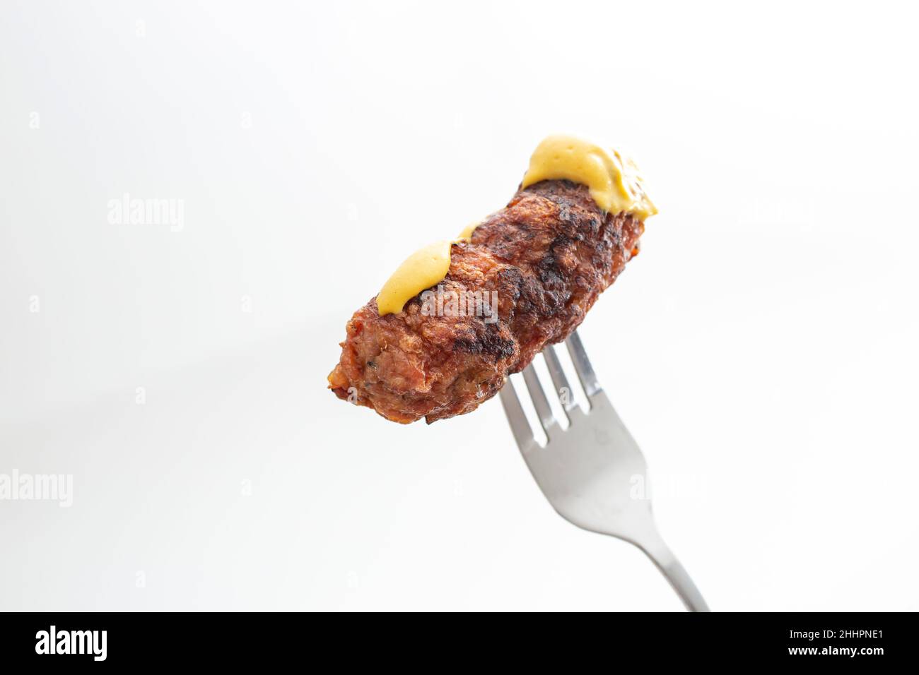 Traditionelles rumänisches gegrilltes Hackfleisch, Mici oder Mititei auf einer Metallgabel Stockfoto