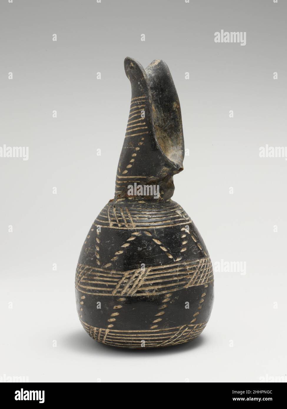Terrakotta-Kanne ca. 2000–1800 v. Chr. zypriotischer Schnabelauslauf, eingeschnittene Bänder und gepunktete Zickzackmuster. Terrakotta-Kanne. Zypriotisch. Ca. 2000–1800 V. CHR. Terrakotta; Schwarz Polierte Ware. Frühzypriotische III-Mittelzypriotische I. Vasen Stockfoto