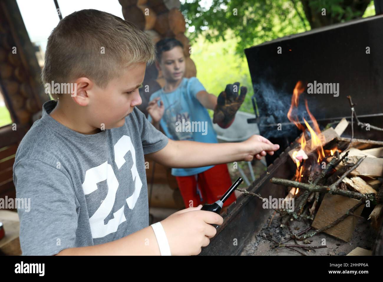 Zwei Jungen zünden Feuerholz im Grill, Karelia Stockfoto