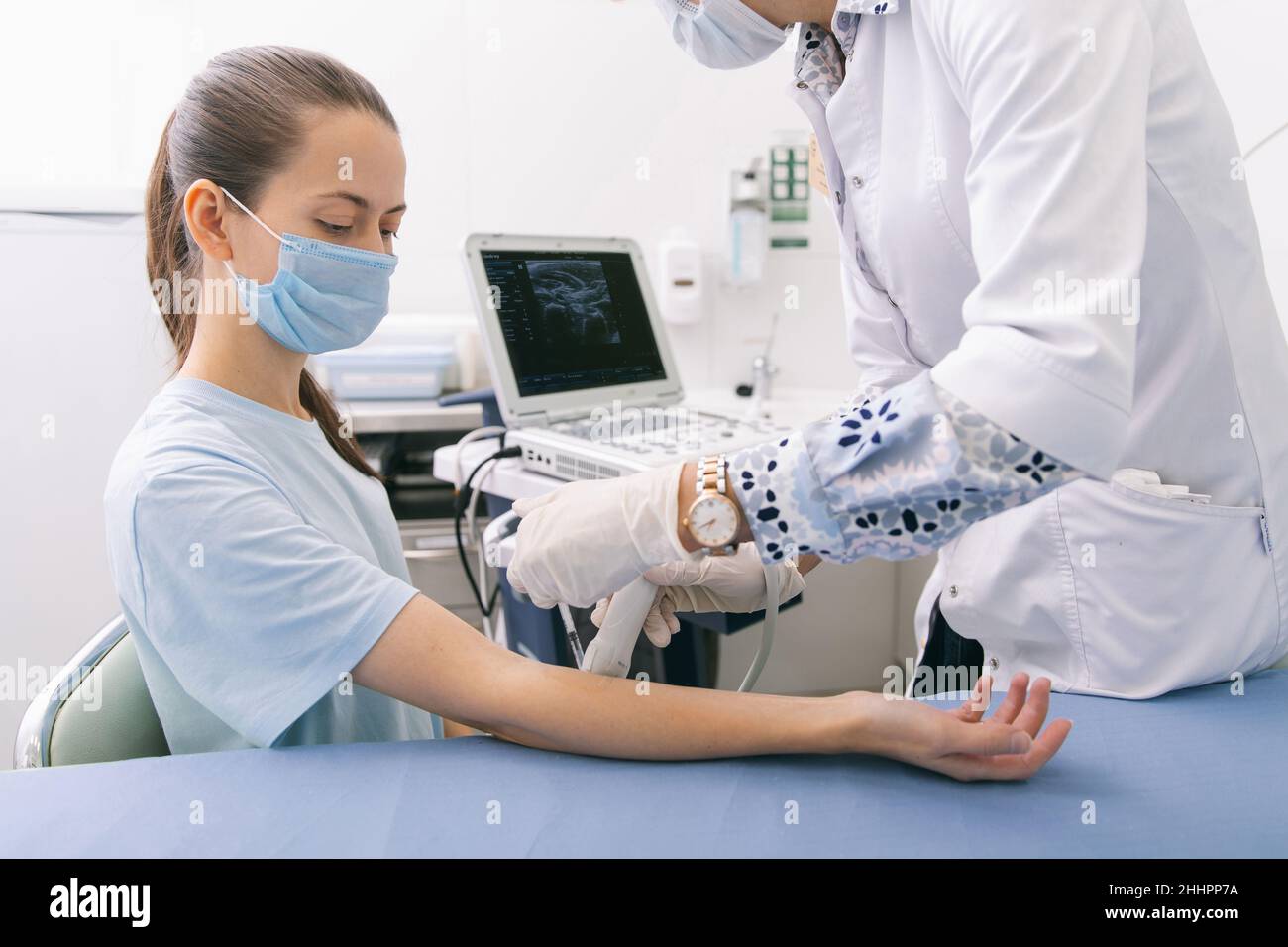 Arzt, der den Ultraschall an der Hand macht, Nahaufnahme. Der Arzt zeigt dem Patienten Ultraschallergebnisse. Medizinische Ultraschalluntersuchung. Rehabilitation Stockfoto