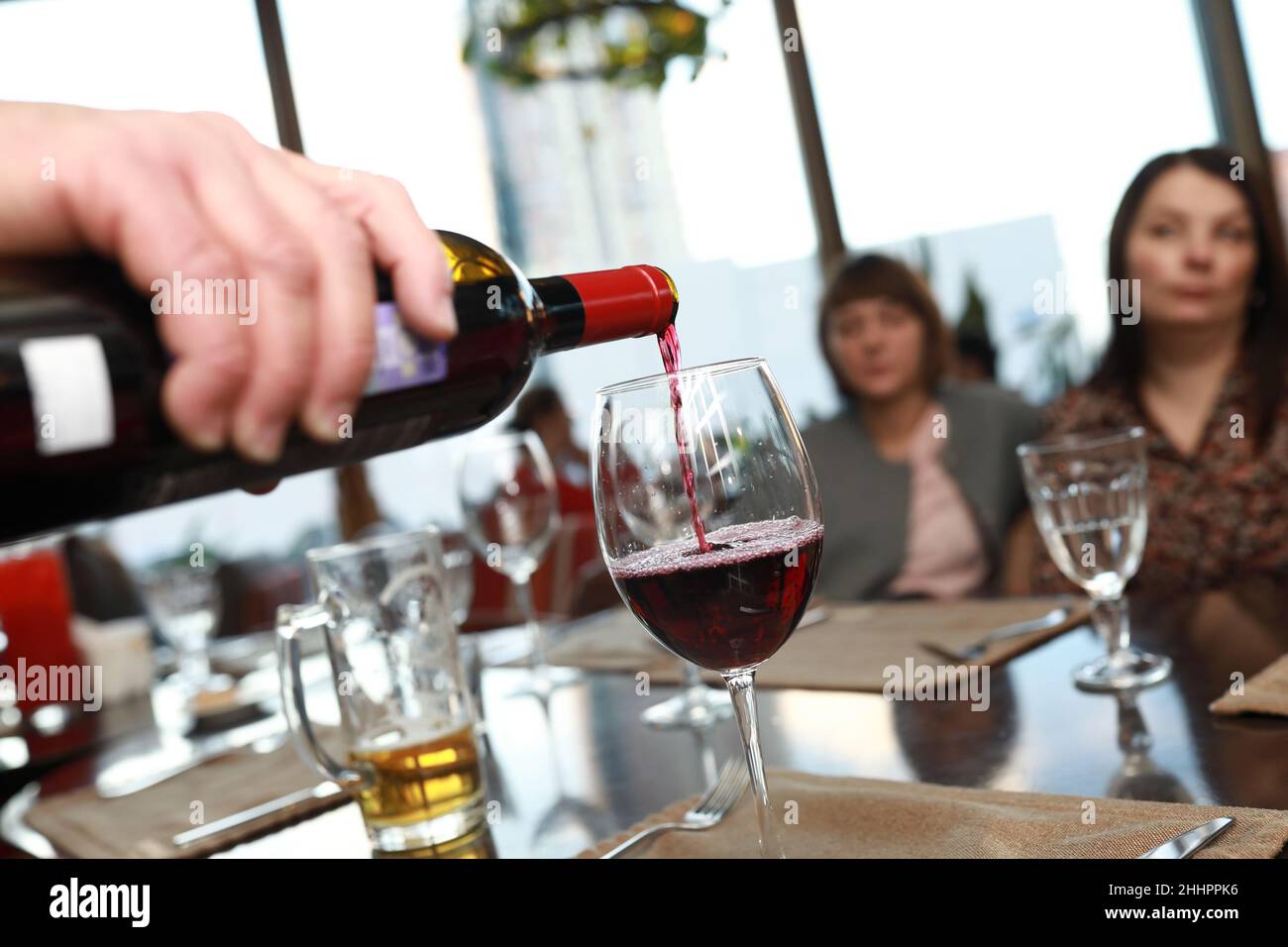 Person, die Rotwein in einem Restaurant eingießt Stockfoto