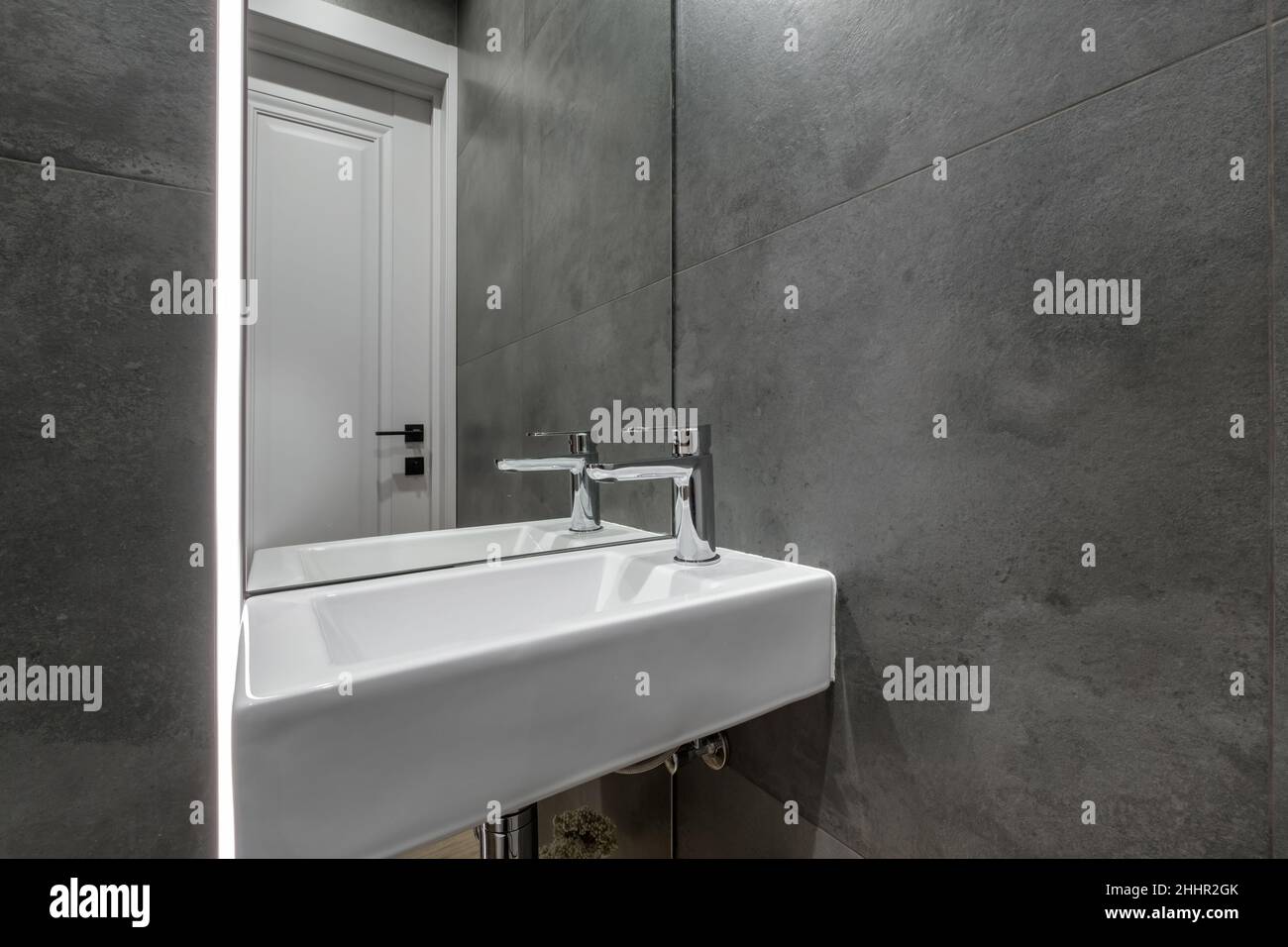 Wasserhahn aus Metall mit Waschbecken und Wasserhahn zum Einschalten und Regeln von kaltem oder heißem Wasser im teuren Badezimmer. Stockfoto