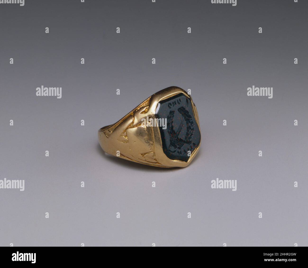 Signet Ring 1864 Ball, Black & Co. American dieser Klassenring wurde von den prominenten New Yorker Juwelieren Ball, Black & Co. Hergestellt und von John K. Elliott nach seinem Abschluss an der United States Military Academy im Jahr 1864 erworben. Das schildförmige Blutstein-Intaglio ist mit einem gekreuzten Lorbeerkranz und Schwert sowie dem gewählten Motto der Klasse von 1864, „Uno Aliam“, ausgestattet. Das Design und das Motto sind rückseitig eingraviert, so dass der Edelstein als Siegel fungieren kann. Die Schultern des Ringes, die aus dem Gebrauch getragen werden, sind mit militärischen Trophäen ausgestattet. Die Innenseite des Rings ist eingraviert „John K. Elliott Graduating Clas Stockfoto