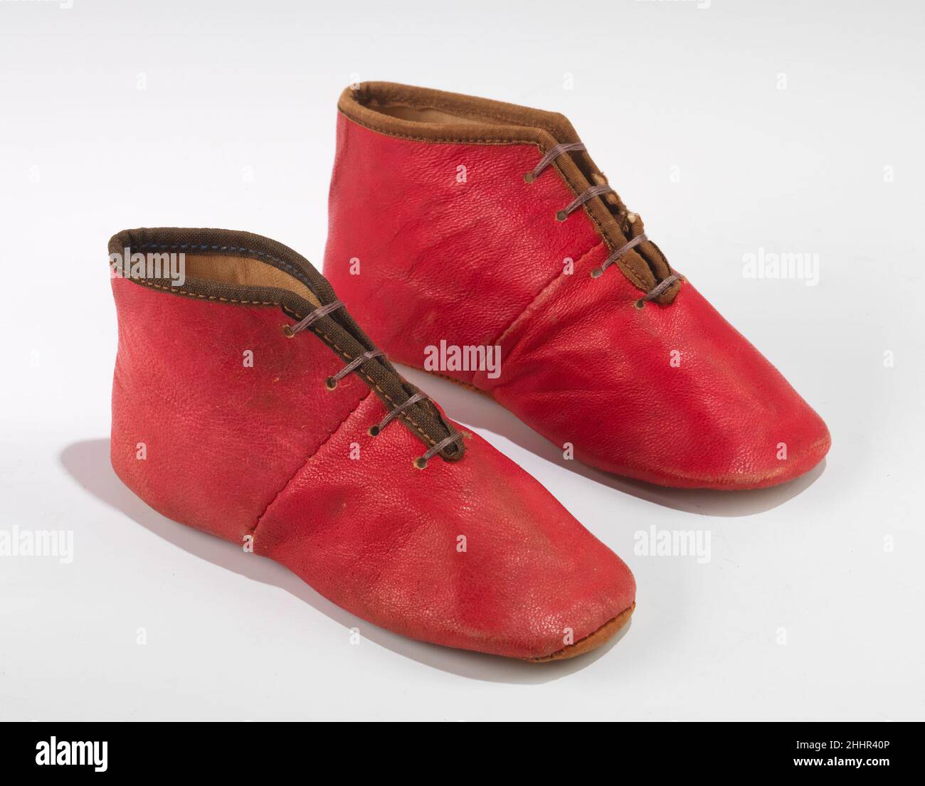 Schuhe 1840–49 amerikanisch aufgrund ihrer winzigen Niedlichkeit und ihrer sentimentalen Verbindung zu Reinheit und Unschuld überleben Babyschuhe in großer Zahl in Familienkollektionen. Obwohl sie für moderne Augen auffiel, war die ursprüngliche, kräftige Farbe, die perfekt auf diesem Paar Schuhe bewahrt wurde, im 19th. Jahrhundert nicht besonders ungewöhnlich. Gerade diese Überraschungsqualität gegenüber den aktuellen Erwartungen (zusammen mit dem sehr guten Allgemeinzustand) macht diese Schuhe im musealen Kontext interessant. Schuhe 158267 Stockfoto