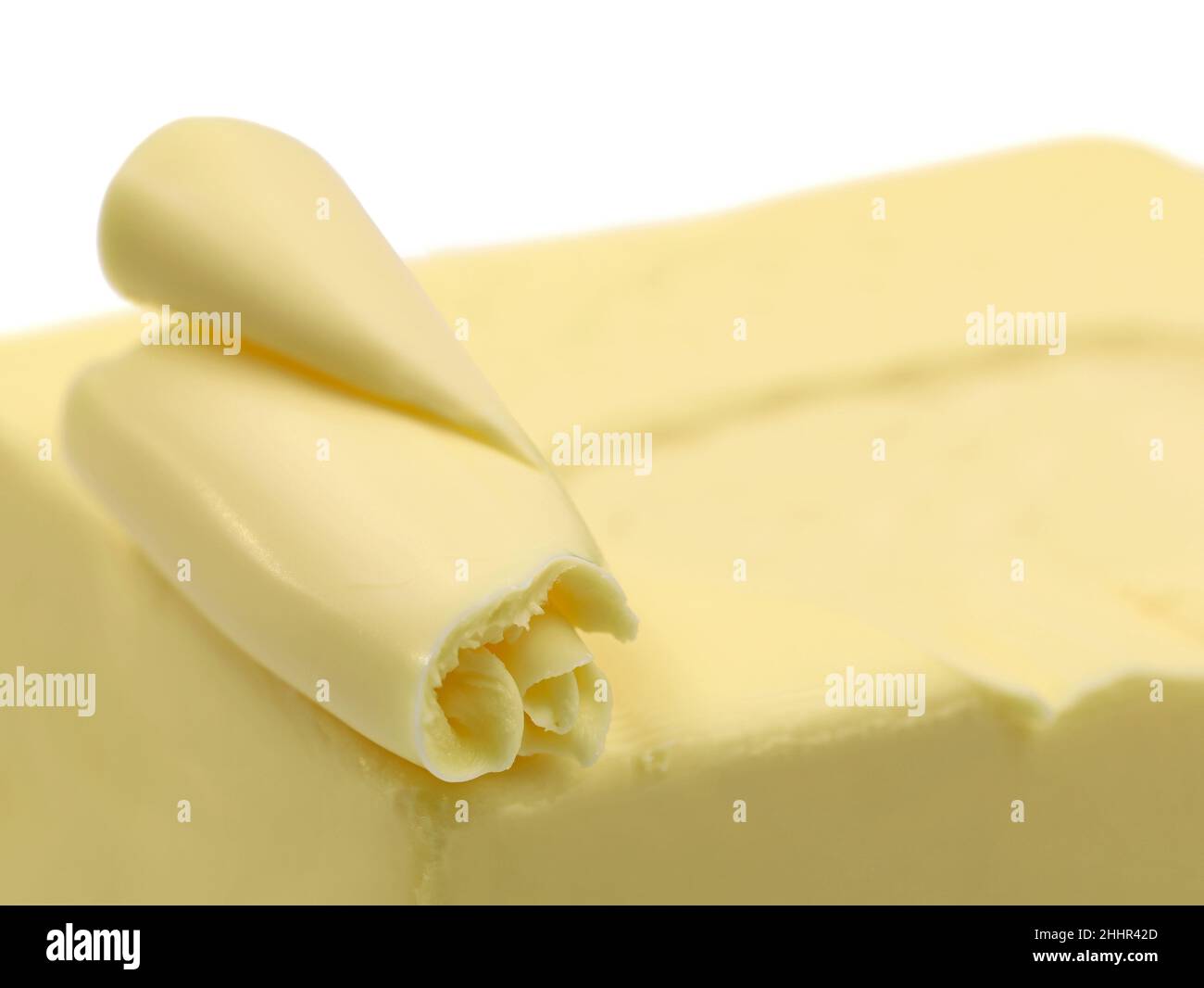 Nahaufnahme von gewellter Butter auf Block isoliert auf weißem Hintergrund Stockfoto