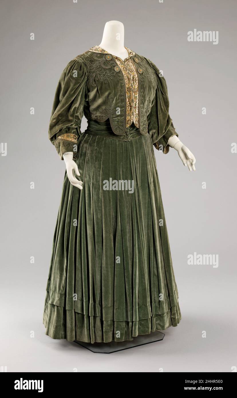 Nachmittagskleid ca. 1903 Chezar & Pillman Dieses Nachmittagskleid ist ein Beispiel für ein in den USA gemachtes Belle Époque-Kleid, das von einem New Yorker Schneidermeister kreiert wurde. Das Label Chezar & Pillman zeigt, dass der Hersteller sich selbst als „The Parisian Ladies“-Schneider gestylt hat, ein Hinweis darauf, dass es sich um eine amerikanische Version der französischen Mode zu dieser Zeit handelt. Das Kleid wird durch mehrere attraktive Details hervorgehoben: Die gute Qualität seiner Stickerei und die Einbeziehung von Strass- und Emaille-Knöpfen.. Nachmittagskleid 159469 Stockfoto