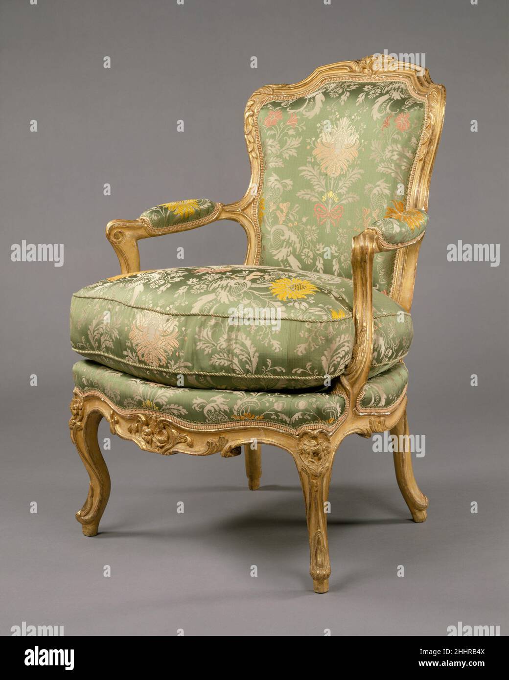 Set aus vier Sesseln (fauteuils en Cabriolet) ca. 1750–60 Französisch die fließende, kurvenlinige Silhouette dieses Sessels, einer aus einem Viererset, setzt ihn fest in die Mitte des 18. Jahrhunderts. Die durchgehende Kurve des Rückens erstreckt sich in die Beine, Schienen und Arme mit einer Anmut, die den Rokoko-Stil verkörpert. Möglicherweise Teil eines größeren Sets, sind die Stühle nicht gestempelt und der Hersteller bleibt unbekannt. Die Stühle sind nicht identisch, weisen aber kleine Unterschiede in ihrer geschnitzten Dekoration auf: Die Blütensprühchen oben auf der Rückseite und in der Mitte der vorderen Sitzschiene variieren von einem zum anderen. Stockfoto