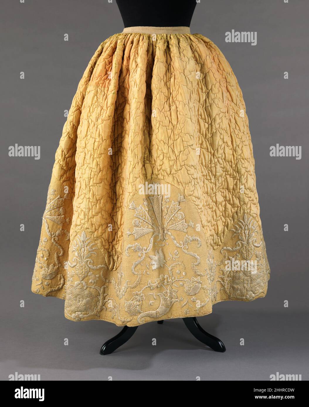 Petticoat 1740–60 Schwedische gesteppte Petticoats waren im Laufe des 18th. Jahrhunderts ein Teil der informellen Kleidung. Ursprünglich diente diese Art von Petticoat der Wärme und der unteren Körperhälfte eine Form zu geben, die die Beine des Trägers verschleiern würde. Als sich die Röcke Anfang des 18th. Jahrhunderts in der Front zu öffnen begannen, wählten Frauen mehr dekorative gesteppte Petticoats, um eine weitere Schicht an Details hinzuzufügen. Dieser besondere Petticoat zeigt den Status des Besitzers durch seine extrem raffinierte Stickerei an, die extrem arbeitsintensiv und teuer gewesen wäre. Petticoat 157859 Stockfoto