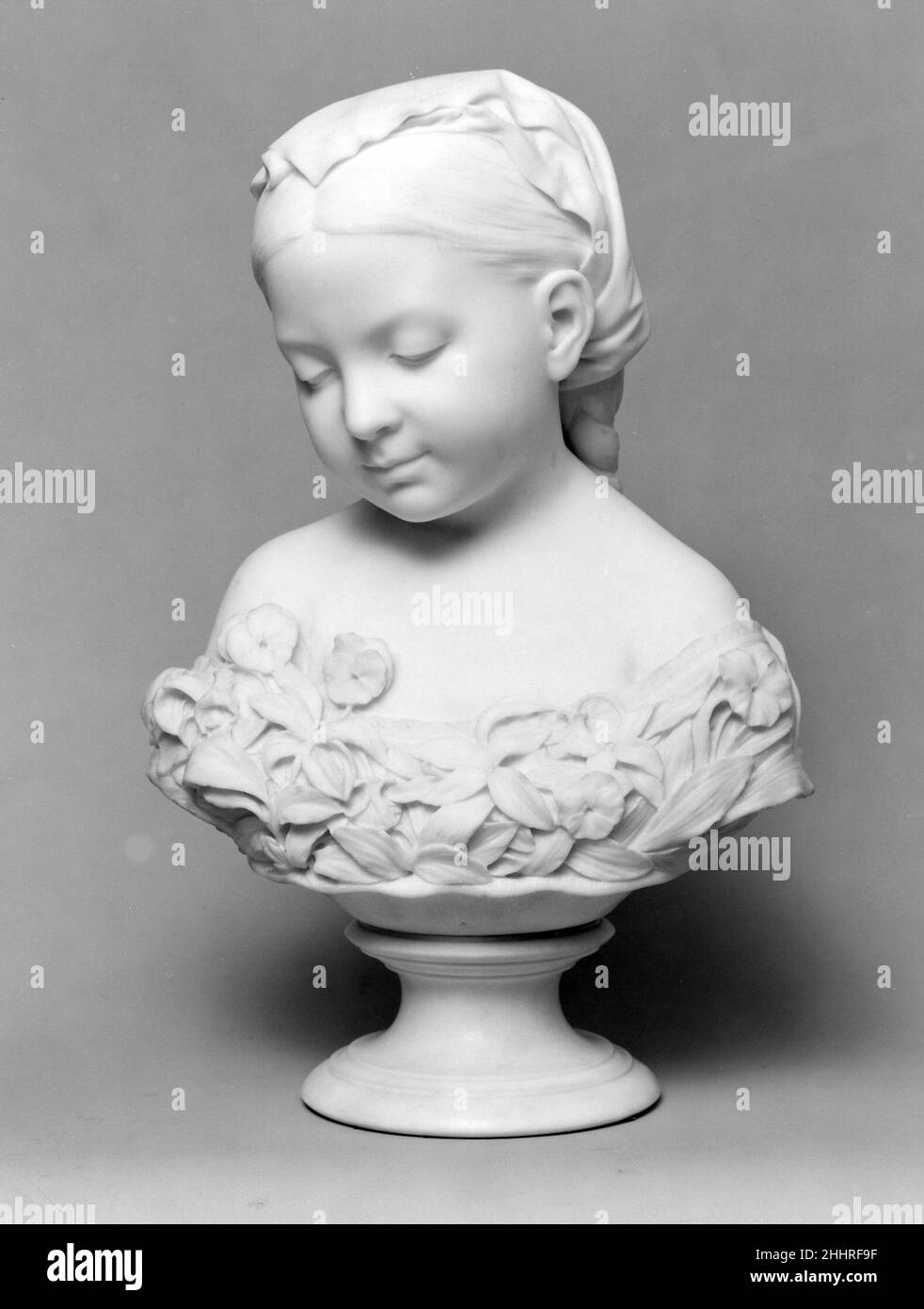La Petite Pensée Ca. 1867–68; geschnitzt 1869 Thomas Ball American Ball, der einen Großteil seiner Karriere im Ausland in Florenz verbrachte, folgte dem Vorbild anderer amerikanischer Bildhauer im Ausland, die sentimentale Darstellungen von Kindern modellierten. Die Haltung dieser Jugendlichen Denkerin, mit ihrem rechten Schulterschub nach vorne, ist etwas kokett, im Gegensatz zu ihrem zurückgebliebenen Blick nach unten. Ihr schulterüberhängerisches Kleid ist mit Spitze verziert und mit stilisierten Blättern überzogen, die mit Stiefmütterchen, einem Symbol der Dreifaltigkeit, verschlungen sind. In der viktorianischen Blumensprache war „Stiefmütterchen“ die anglikisierte Schreibweise des französischen Pensée, oder „nachdenklich“ Stockfoto
