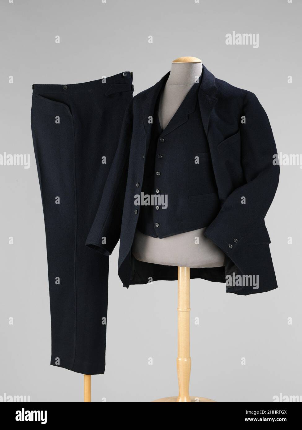 Anzug 1901 The Walter Bugbee Company American Dieses Beispiel eines Herren-Business-Anzugs aus dem frühen 20th. Jahrhundert enthält belebende Details wie geschwungene westliche Hosentaschen und doppelte Ziernähte an den Seitennähten, Revers, Manschettennähten und Taschen der Hose. Dieser Anzug ist der früheste in der Kollektion, für den auf dem Kundenetikett handschriftliche Notizen mit dem Namen des Kunden und dem Datum des Kleidungsstücks zu finden sind. Anzug 159405 Stockfoto
