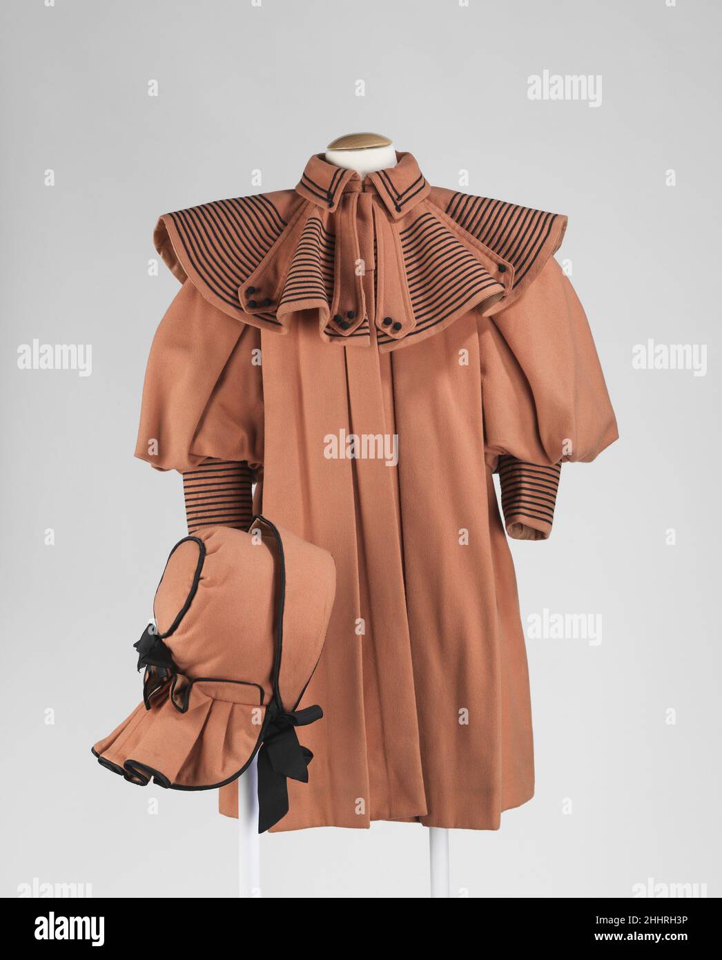 Ensemble ca. 1895 American Featured ist ein hervorragendes Beispiel für ein komplettes Mädchenensemble von höchster Qualität. Oft werden Ensembles wie dieses aus verschiedenen Gründen getrennt, so dass es ziemlich selten ist, alle entsprechenden Stücke zu haben. In dieser Zeit folgte die Kleidung der Kinder sehr der Damenmode. Mit dem modischen Umschlagkragen und den vollen Ärmeln hat dieser Mantel alle Markenzeichen des 1890s.. Ensemble 159563 Stockfoto