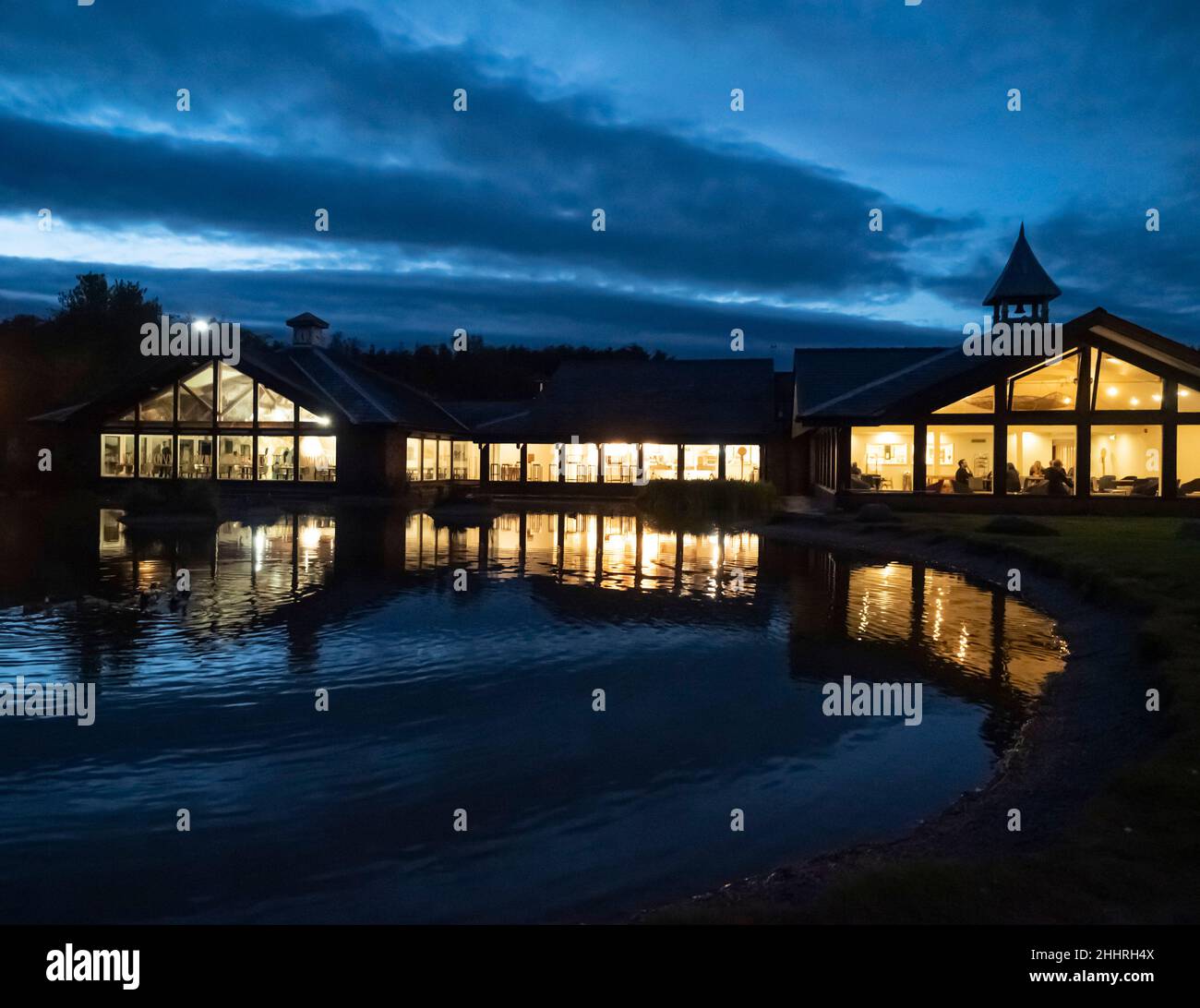 Tebay M6 in Richtung Norden fährt in der Nähe von Kendal in Cumbria, in der Dämmerung mit den Lichtern des Restaurants und dem Teich. Stockfoto