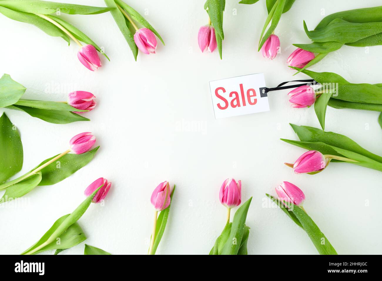 Spring Flat Lay mit Verkaufsetikett und Tulpen auf dem Tisch. Stockfoto