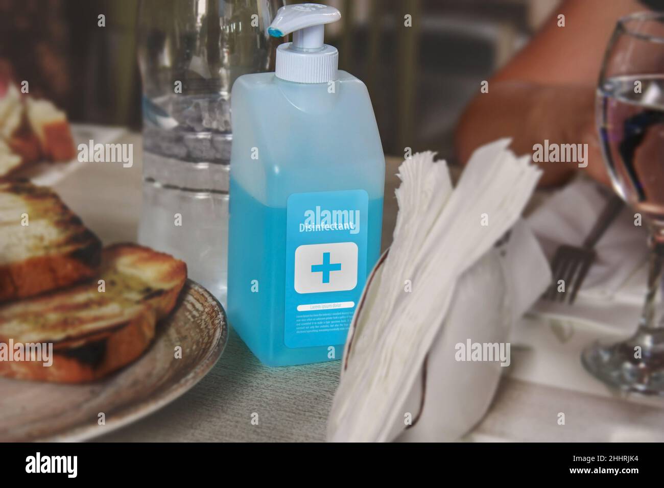 Desinfektionsflasche auf einem Tisch im Restaurant zur Vorbeugung der COVID-19 Coronavirus-Pandemie. Kleine Unternehmen sind in Schwierigkeiten, ohne Tourismus und Kunden. Stockfoto