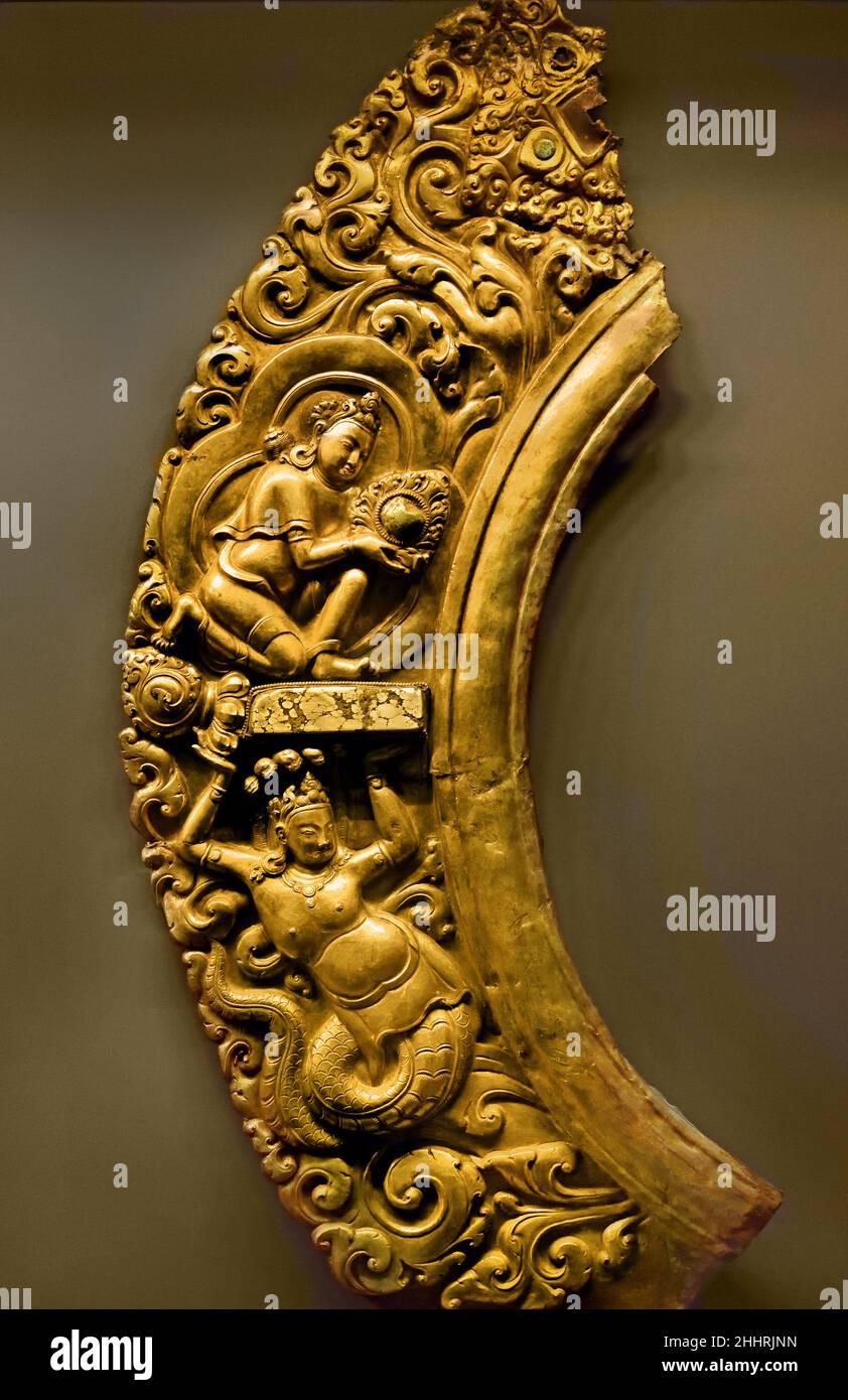 Manidhara und Nagaraja Zentraltibet 15th Jahrhundert Tibetisch ( Fragment, Teil des leuchtenden Heiligenbildes einer Statue, typische Produktion von Newar Handwerkern, die in Tibet im 15th. Jahrhundert tätig sind. Die Kletterpflanze zieht die Voluten nach innen, in die die Figuren eines Nagaraja (König der Schlangen und Beschützer der Schätze, die in den Tiefen des Wassers enthalten sind) und Manidhara (der Juwelenträger) platziert sind. Manidhara und Nagaraja beziehen sich zusammen auf den Mythos von Nagarjuna.) Stockfoto