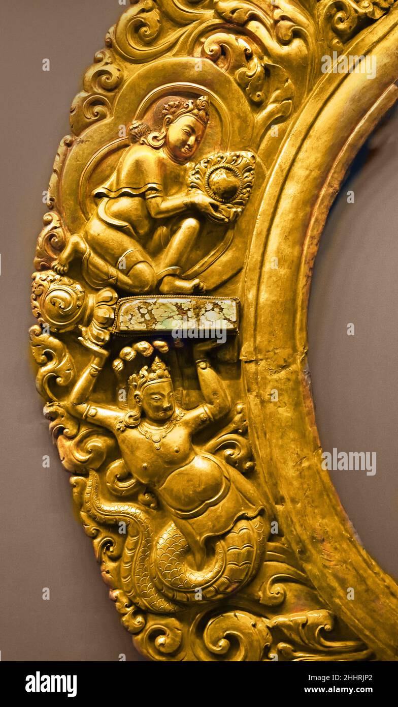 Manidhara und Nagaraja Zentraltibet 15th Jahrhundert Tibetisch ( Fragment, Teil des leuchtenden Heiligenbildes einer Statue, typische Produktion von Newar Handwerkern, die in Tibet im 15th. Jahrhundert tätig sind. Die Kletterpflanze zieht die Voluten nach innen, in die die Figuren eines Nagaraja (König der Schlangen und Beschützer der Schätze, die in den Tiefen des Wassers enthalten sind) und Manidhara (der Juwelenträger) platziert sind. Manidhara und Nagaraja beziehen sich zusammen auf den Mythos von Nagarjuna.) Stockfoto