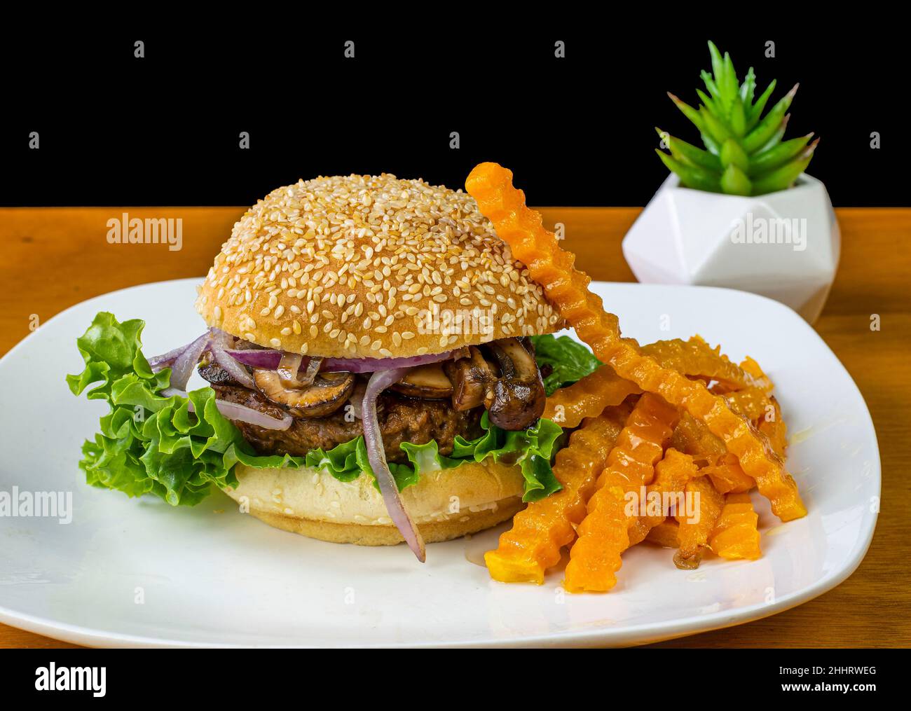 Auf pflanzlicher Basis Hamburger Top mit sautierten Pilzen und Zwiebeln und Butternut Pommes frites. Stockfoto