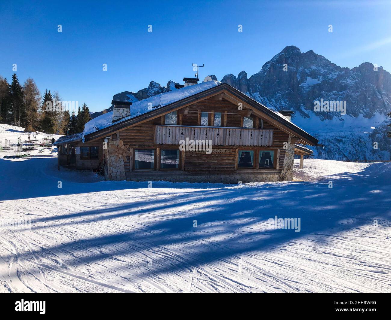 Ein Blick auf ein Haus in einem schneebedeckten Feld mit großen Bäumen Stockfoto