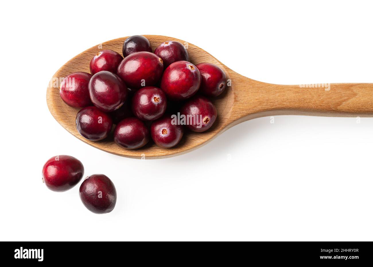 Rote reife Preiselbeeren in einem Holzlöffel isoliert auf weißem Hintergrund. Zugeschnittenes Bild von Löffel voll von frischen Bio-Waldbeeren Makro. Antioxidans. Stockfoto
