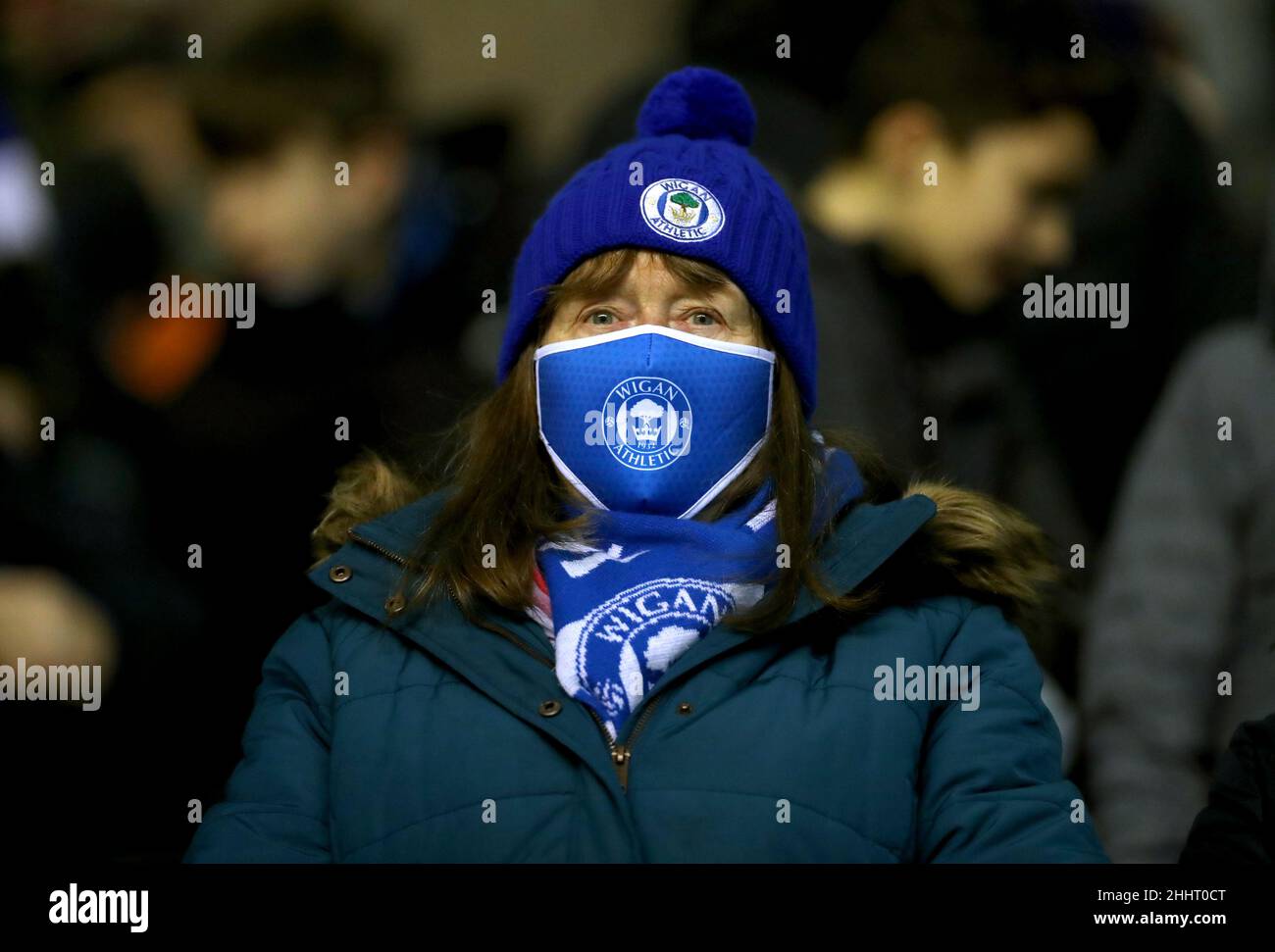 Ein Wigan Athletic-Fan trägt eine Gesichtsmaske auf den Tribünen während des Viertelfinalmatches der Papa John's Trophy im DW Stadium, Wigan. Bilddatum: Dienstag, 25th. Januar 2022. Stockfoto