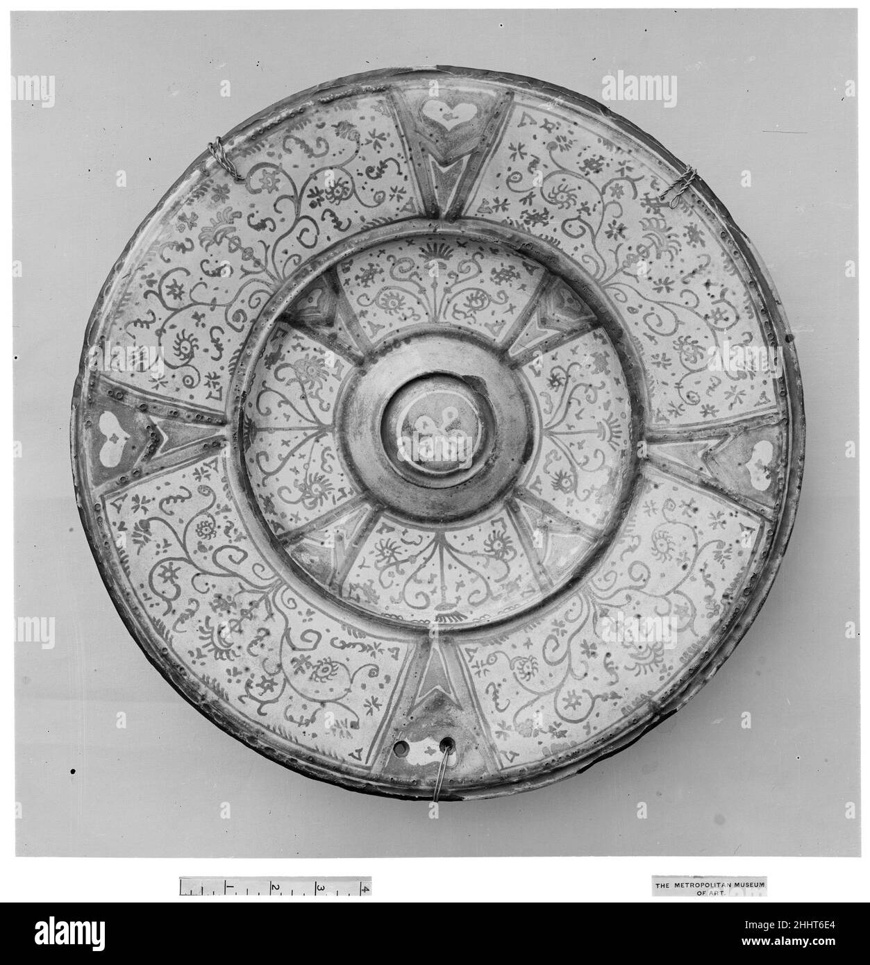 Dish 18th Century Spanish Zinn-glasierten Steingut, von denen Lusterware ist ein Typ, wurde im Nahen Osten im neunten und zehnten Jahrhundert entwickelt, um die Porzellane in China produziert zu imitieren. Die opake weiße Glasur verbarg den Tonkörper, der von hellem Buff bis zu Ziegelrot reichen konnte, was brillante Effekte ermöglichte, indem die weiße Oberfläche mit Metalloxiden bemalt wurde, die zu einer Reihe von Farben abgefeuert wurden. Diese Technik sowie die Verwendung von metallischem Glanz – einer irisierenden, kupferfarbenen Glasur – verbreitete sich in der muslimischen Welt und kam im 13. Jahrhundert unter die Töpfer von Valencia Stockfoto