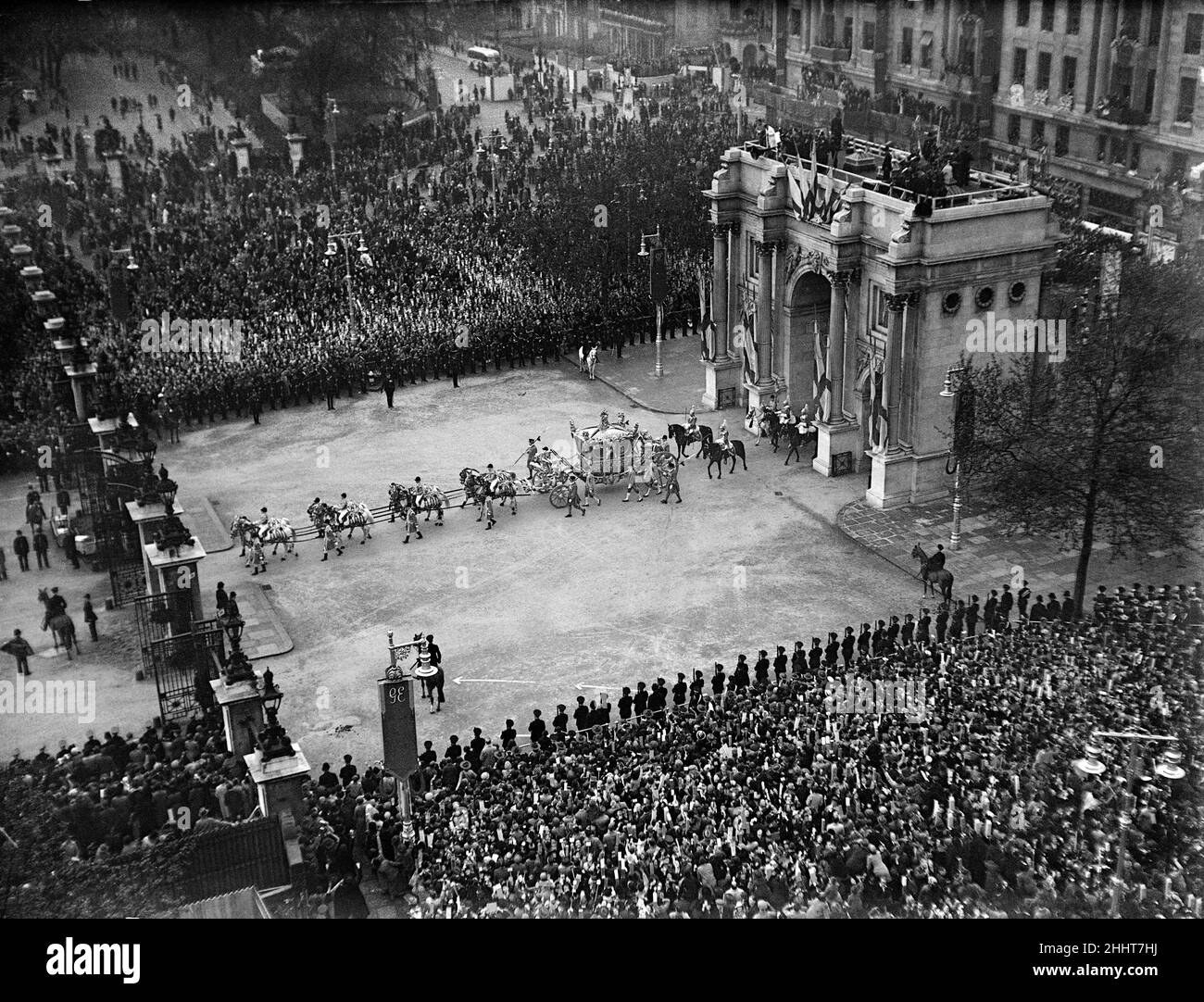 Krönung von König George VI. Der goldene Staatsbus mit König George VI fährt durch Marble Arch zum Cumberland-Tor im Hyde Park auf seiner Rückfahrt zum Buckingham Palace, während Tausende von Menschen am Straßenrand jubeln. 12th Mai 1937. Stockfoto