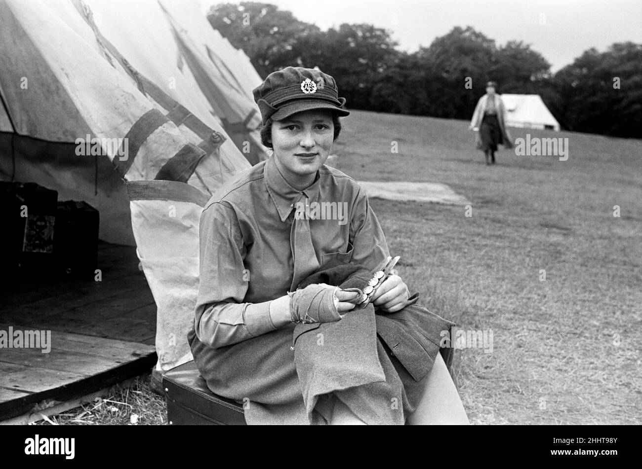 Eine neue W.A.T.S. Rekrut im Cowshot Manor Camp Brookwood, Surrey poliert ihre Tunikaknöpfe vor einer Inspektion durch Sir Malcolm Fraser und Lord Ashcombe. August 1939 Stockfoto