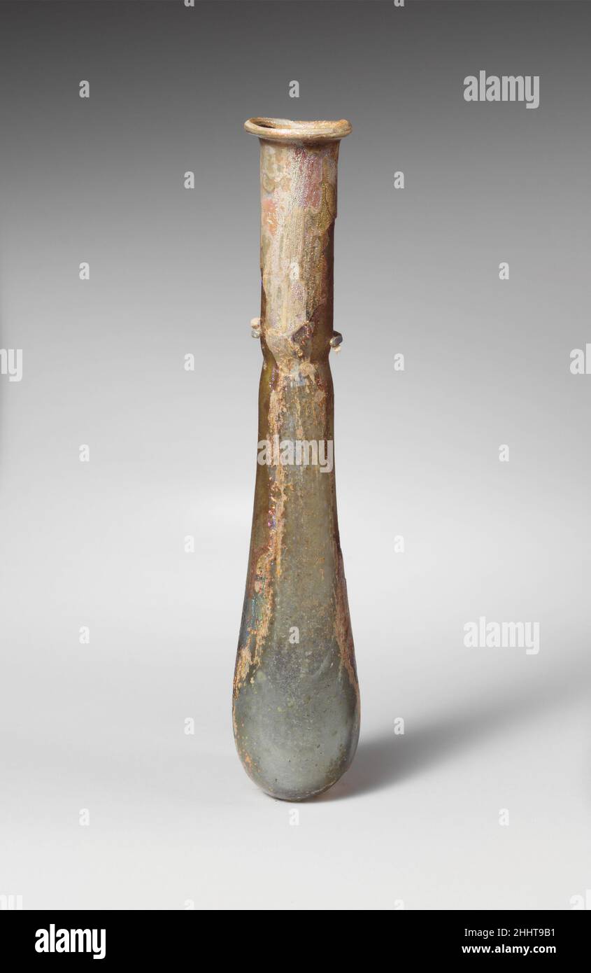 Parfümflasche aus Glas 1st–2nd Jahrhundert n. Chr. römisch Durchscheinend blassblaugrün.feiner Rand ausgeklappt, über und in; auffahlender Mund; zylindrischer Hals, Mit tiefem eingedorntem Einzug um die Basis; langgestreckter eiförmiger Körper; sehr kleiner, unebener Boden. Intakt; Nadelstich-Blasen und Blasen-Streifen; stumpfend, leichtes Lochfraß und Flecken brillanter irisierender Verwitterung. Parfümflasche aus Glas 244687 Stockfoto