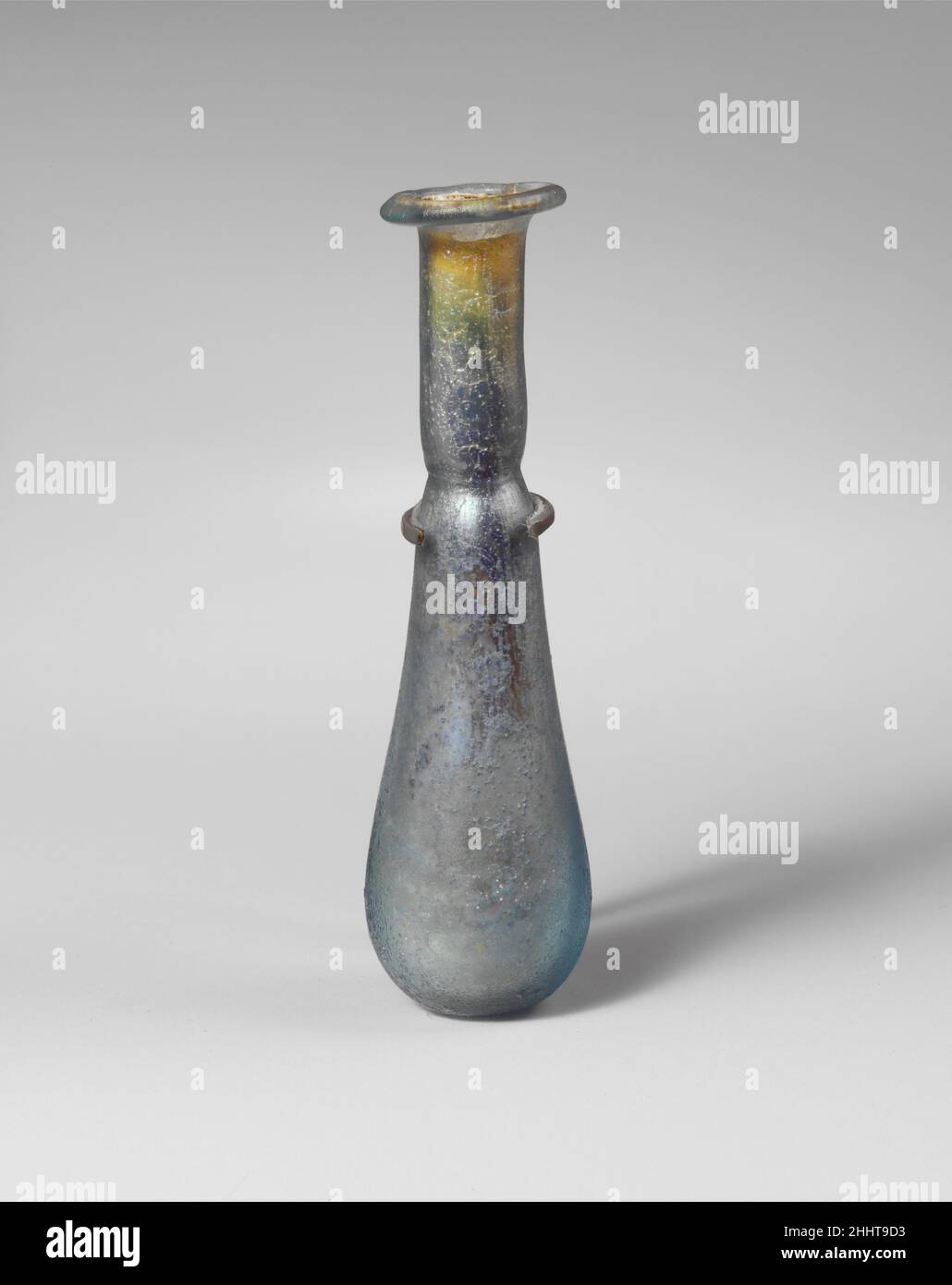 Parfümflasche aus Glas 1st–2nd Jahrhundert n. Chr. römisches kleines Unguentarium.Lichtdurchlässig hellblau.Rand ausgeklappt, über und in; abfackelnder Mund; schlanker zylindrischer Hals mit eingedornter Einbuchtung um den Boden; länglicher ovoider Körper; kleiner abgeflachtter Boden.intakt; Nadelstich und ein paar größere Blasen; Abstumpfen an der Außenseite, brilliante irisierende Verwitterung im Inneren; Hals blockiert durch verkrusteten Boden und etwas lose Erde in der Flasche. Parfümflasche aus Glas 244681 Stockfoto