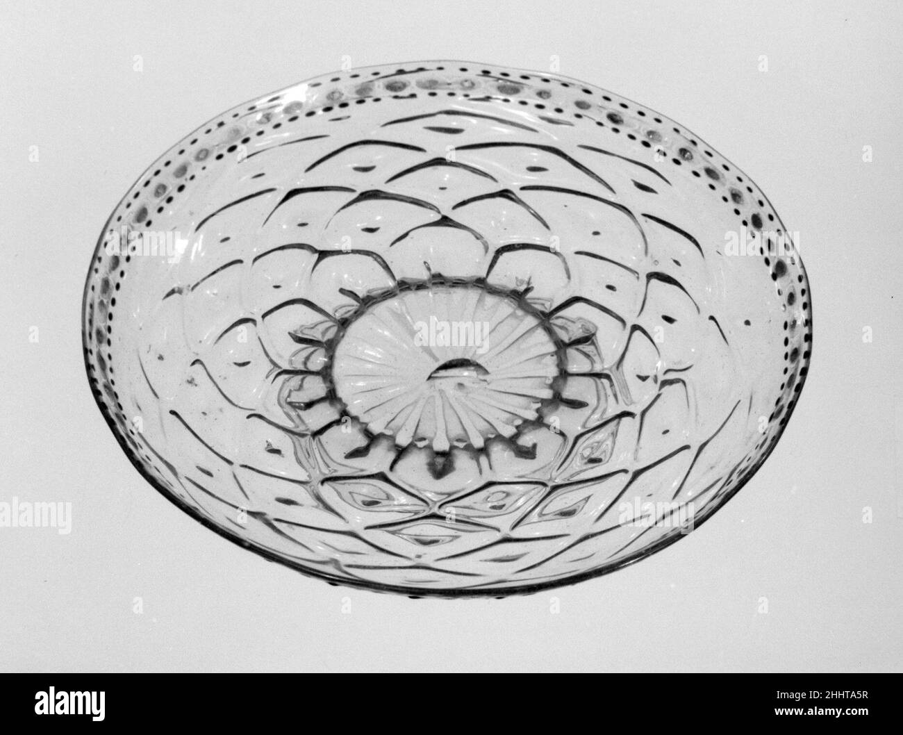 Tazza 16th Jahrhundert Italienisch, Venedig (Murano) während der Renaissance wurden venezianische Glasmacher, die auf der Insel Murano arbeiteten, in ganz Europa für ihre feinen und funkelnden Arbeiten gefeiert. „cristallo“ genannt, das die Klarheit des Bergkristalls nachahmt, könnte das Medium in den Händen der erfahrensten Glasbläser wunderbar manipuliert, unterschiedlich gedehnt, papierdünn flach oder spielerisch verdreht oder mit spektakulären Mustern in Formen geblasen werden. Tazza. Italienisch, Venedig (Murano). 16th Jahrhundert. Glas. Glas Stockfoto