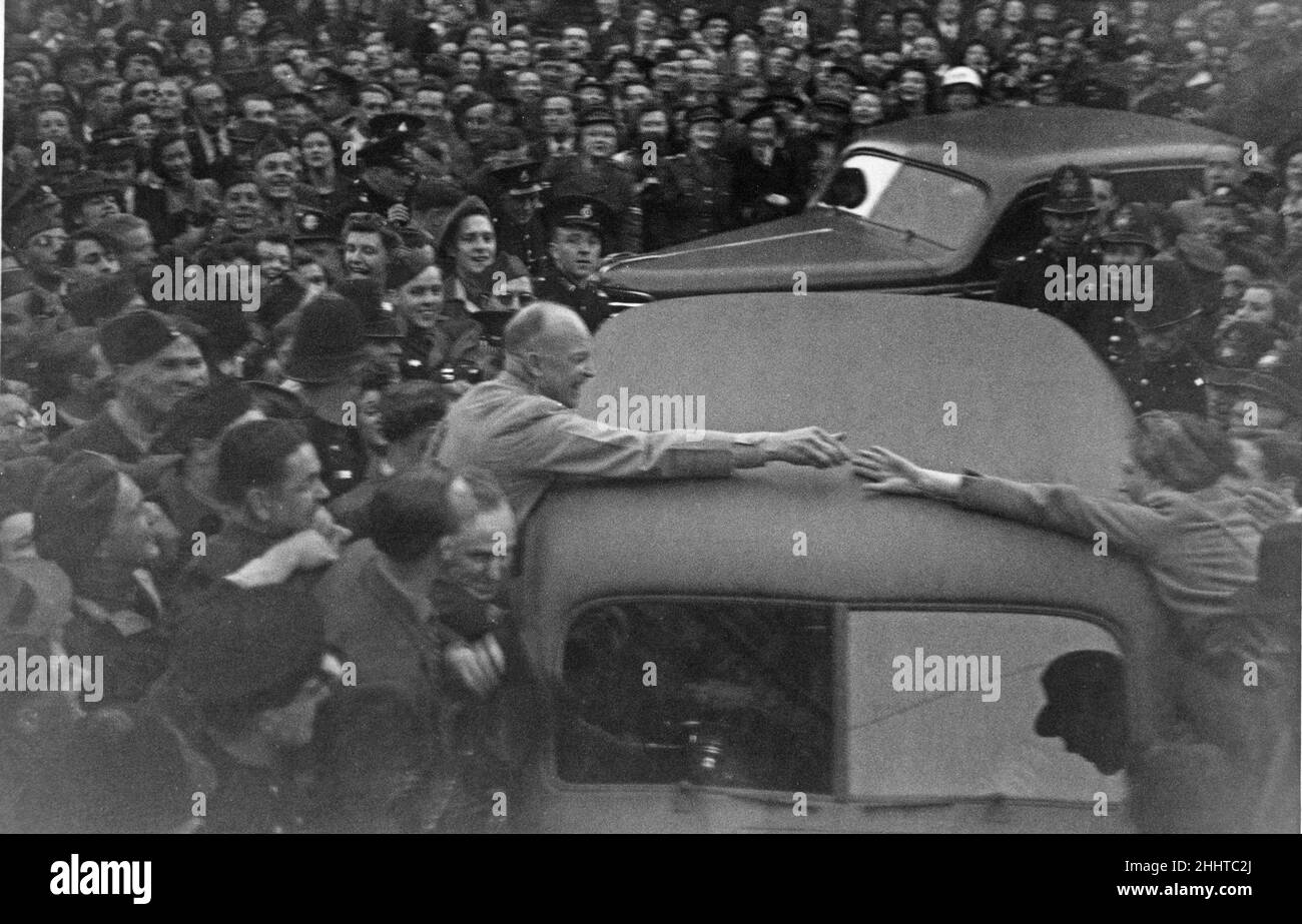 General Dwight D Eisenhower, Oberbefehlshaber der Alliierten, schüttelt sich die Hände mit einer Frau aus der Menge, die sein Auto bewegt hat. Eisenhower war in London, um sich mit Premierminister Winston Churchill in der Downing Street zu treffen, um die Situation in Europa nach der Niederlage Nazi-Deutschlands zu diskutieren. 16th Mai 1945 Stockfoto