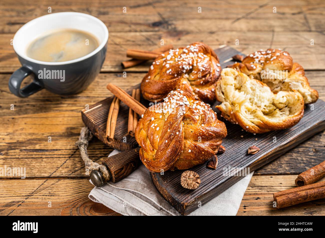 Frühstück mit Zimtbrötchen oder Brötchen, schwedisches Kanelbullar. Holzhintergrund. Draufsicht Stockfoto