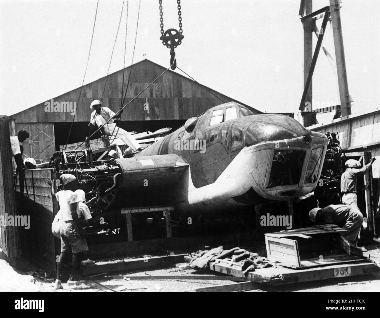 Chinesische Arbeiter eröffnen den Fall, als der Hochgeschwindigkeits-Jagdbomber Bristol Blenheim Mark IV (Longnose) während des Zweiten Weltkriegs auf einer RAF-Station in Malaya eintreffen wird.18th. November 1941. Stockfoto