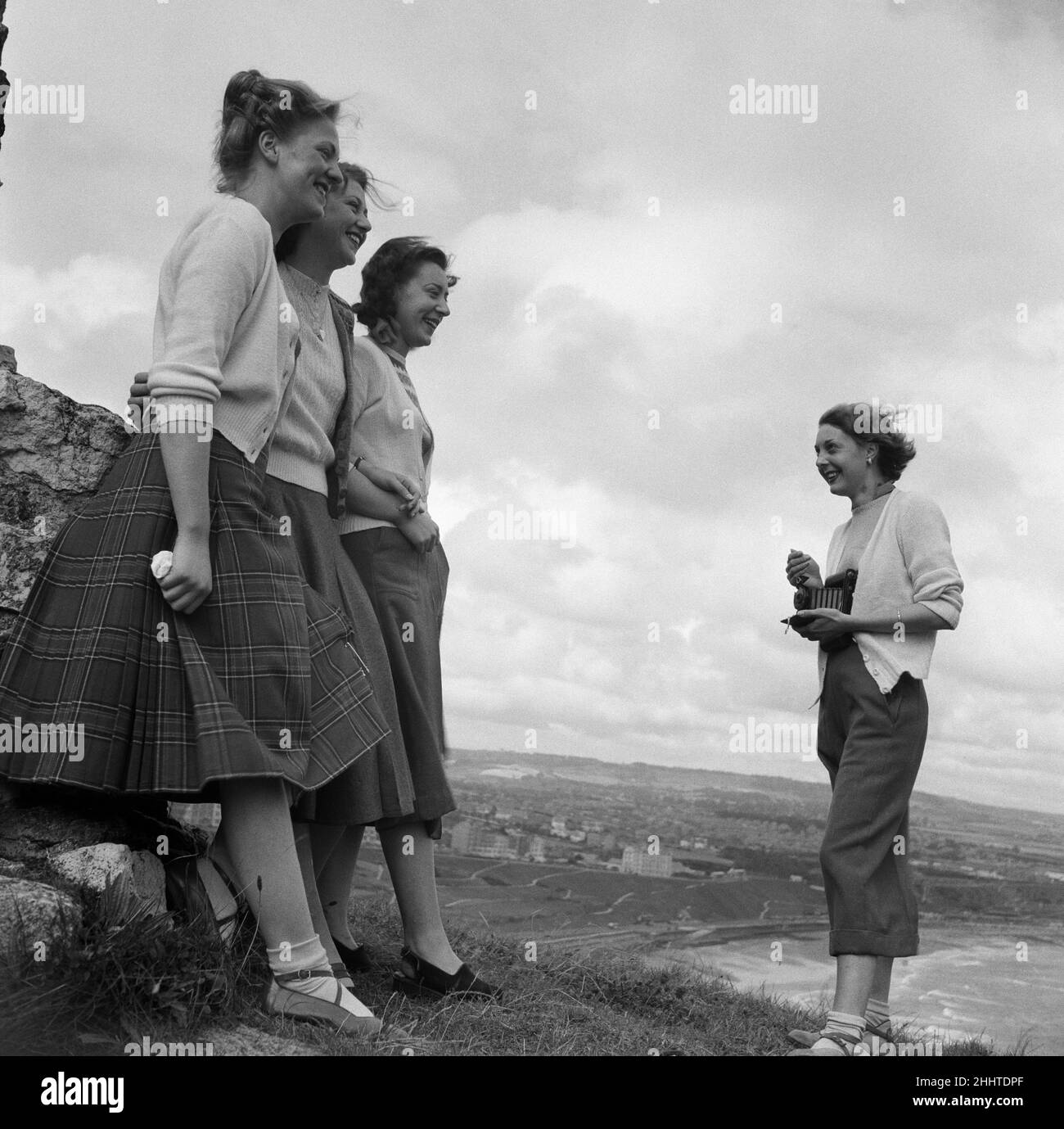 Eine Frau, die ein Foto von drei Frauen in einem Küstengebiet in North Yorkshire macht. 11th. August 1949. Stockfoto