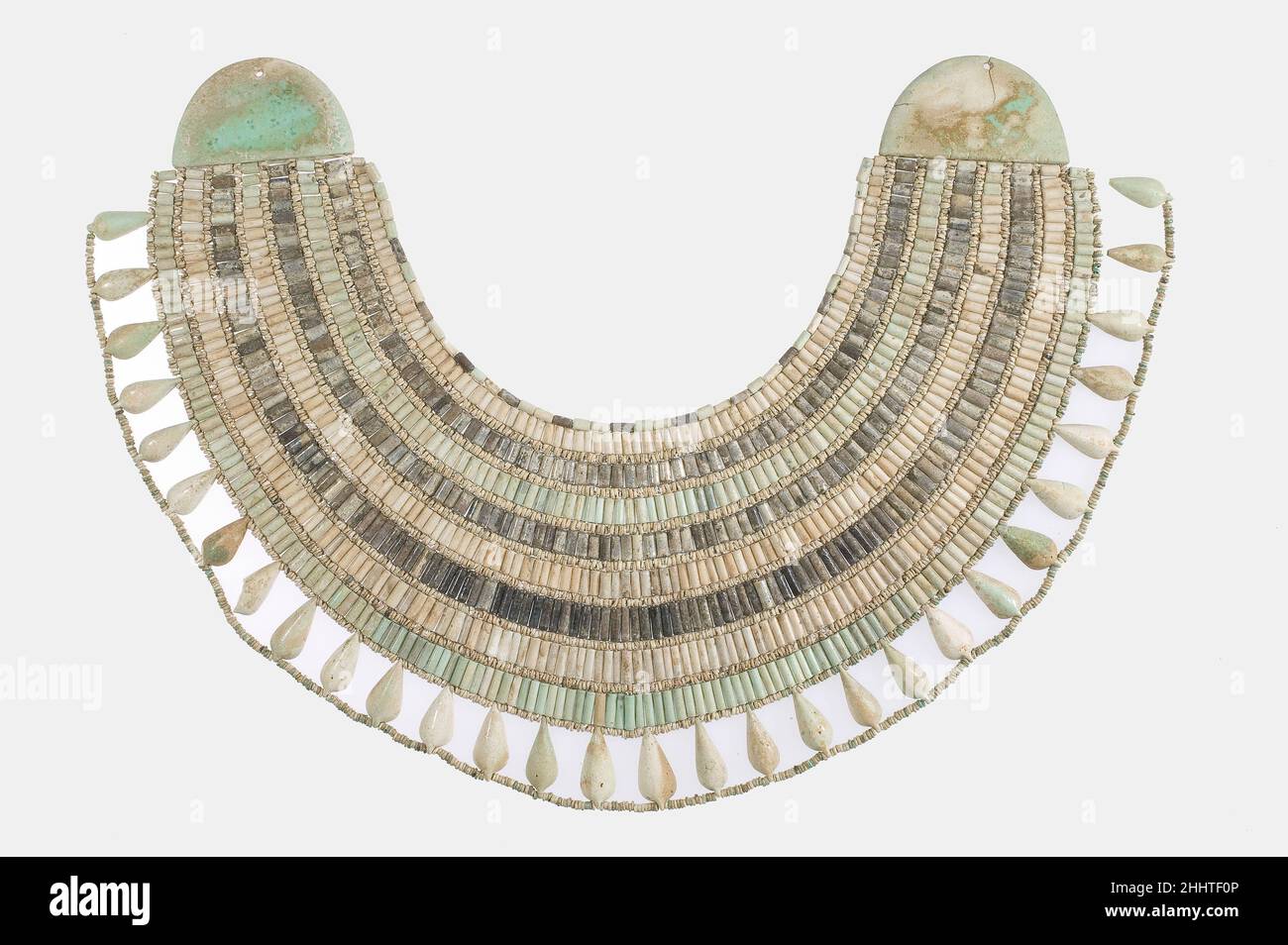 Breiter Kragen ca. 1981–1640 v. Chr. Mittleres Königreich Dieses Schmuckstück ist ein breiter Kragen, eine Art mehrsträngige Halskette, die die obere Brust und Schultern des Trägers bedeckt. Die breiten Halsbänder waren seit dem Alten Königreich beliebt und das Stück stellt hier einen konventionellen Typ dar, der aus Perlen und halbrunden Endstücken (Endstücken) besteht. Es verfügt über acht abwechselnd farbige Reihen vertikal platzierter zylindrischer Perlen, die durch Reihen kleiner Scheibenperlen getrennt sind. Am Boden befinden sich unterschiedlich geformte Elemente, sogenannte Tropfperlen.als dieser Kragen ausgegraben wurde, hatte sich die uralte Schnur verschlechtert, BU Stockfoto