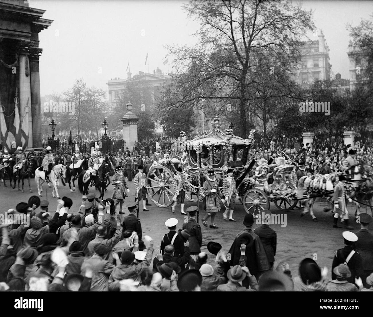 Krönung von König Georg VI. Der goldene Staatsbus mit König George VI fährt auf der Rückfahrt zum Buckingham Palace durch Marble Arch, während Tausende von Menschen am Straßenrand jubeln. 12th Mai 1937. Stockfoto