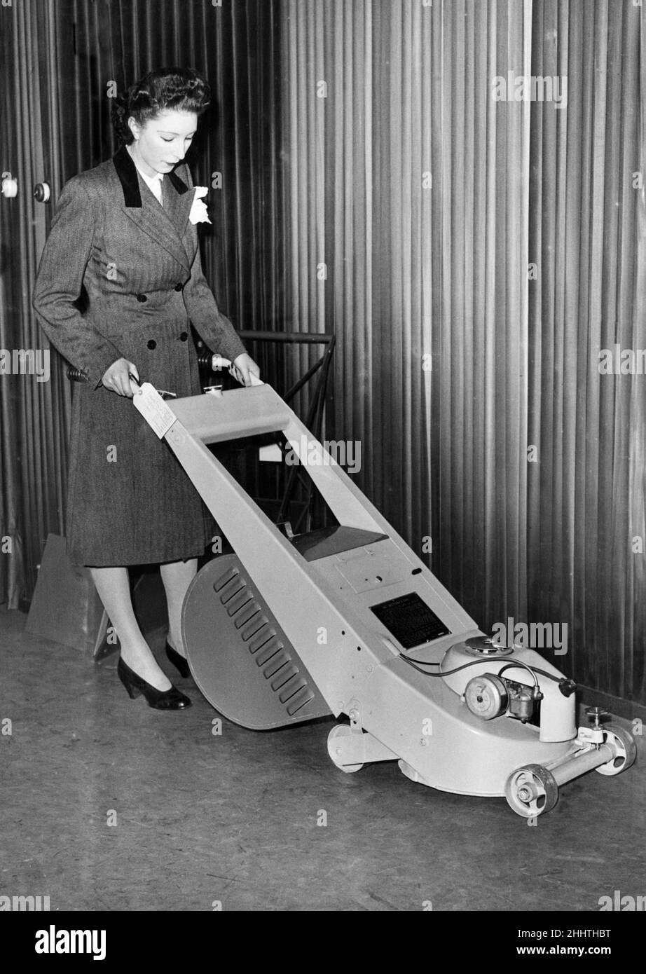 Eine Frau, die einen Rasenmäher mit Bach ausprobiert, der mit Benzin- oder Elektromotor auf der Britain Can Make IT-Ausstellung in London im August 1946 gefahren werden kann. Stockfoto