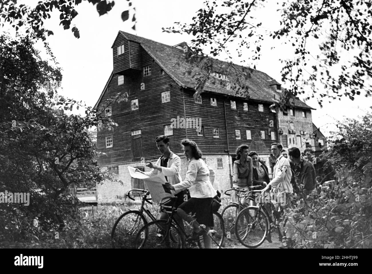 Der Youth Hostel Association hat die elisabethan Houghton Mill aus dem 16th. Jahrhundert am Fluss Ouse in der Nähe von St. Ives, Cambridgeshire, für 56 Hosteller eingerichtet. Sie zahlen 1/- pro Nacht und schlafen dort, wo die Graffsteine einmal den Mais gemahlen haben. Ein Teil der Mühle ist als Kochhaus ausgestattet und die Wanderer bringen Würstchen und andere Speisen mit und kochen für sich selbst. Mai 1945. Stockfoto