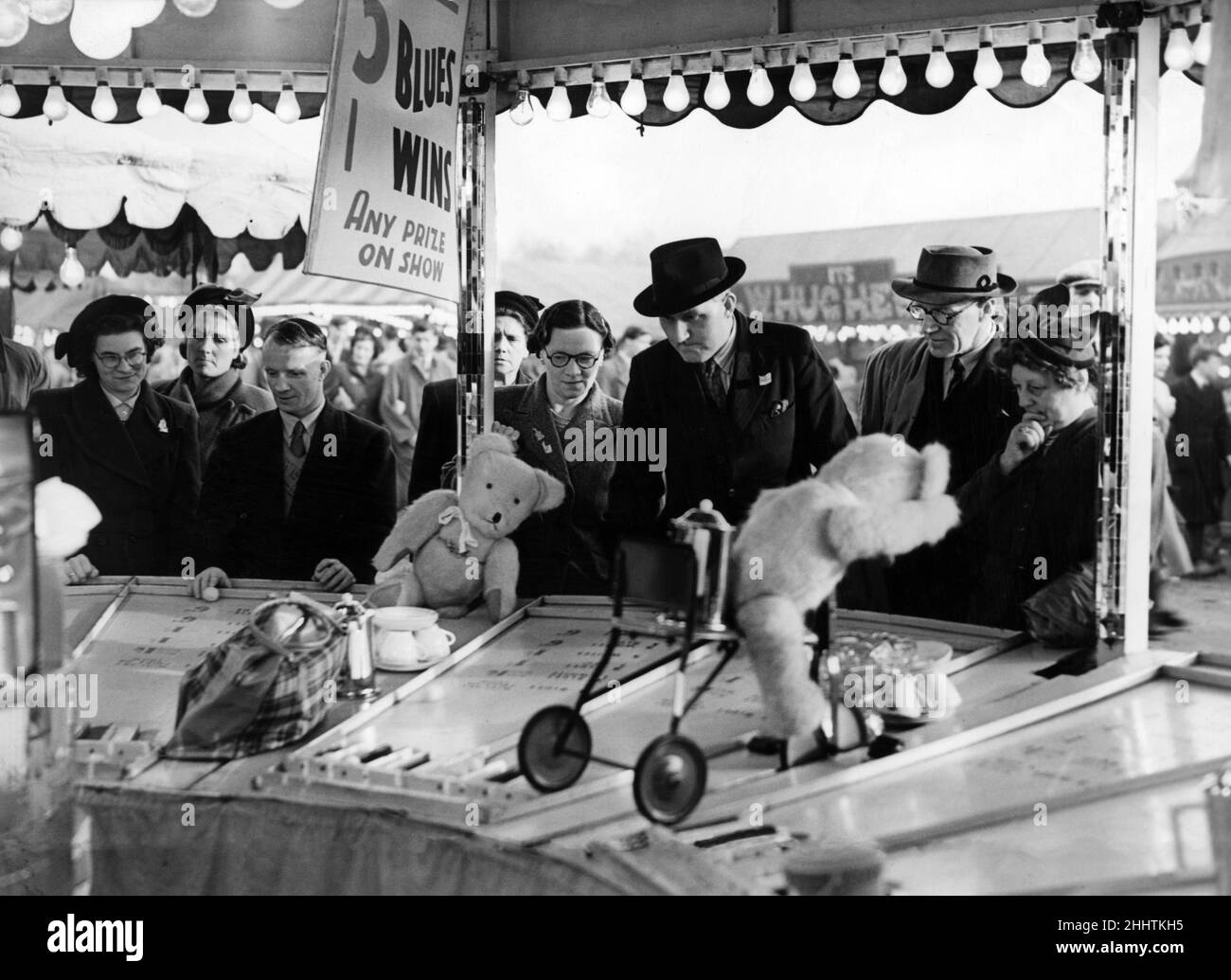 Spaßsuchende versuchen ihr Können an einem der Seitenführungen auf der Hoppings-Messe, die auf dem Town Moor in Newcastle upon Tyne, Tyne und Wear stattfindet. 19th. Juni 1951. Stockfoto