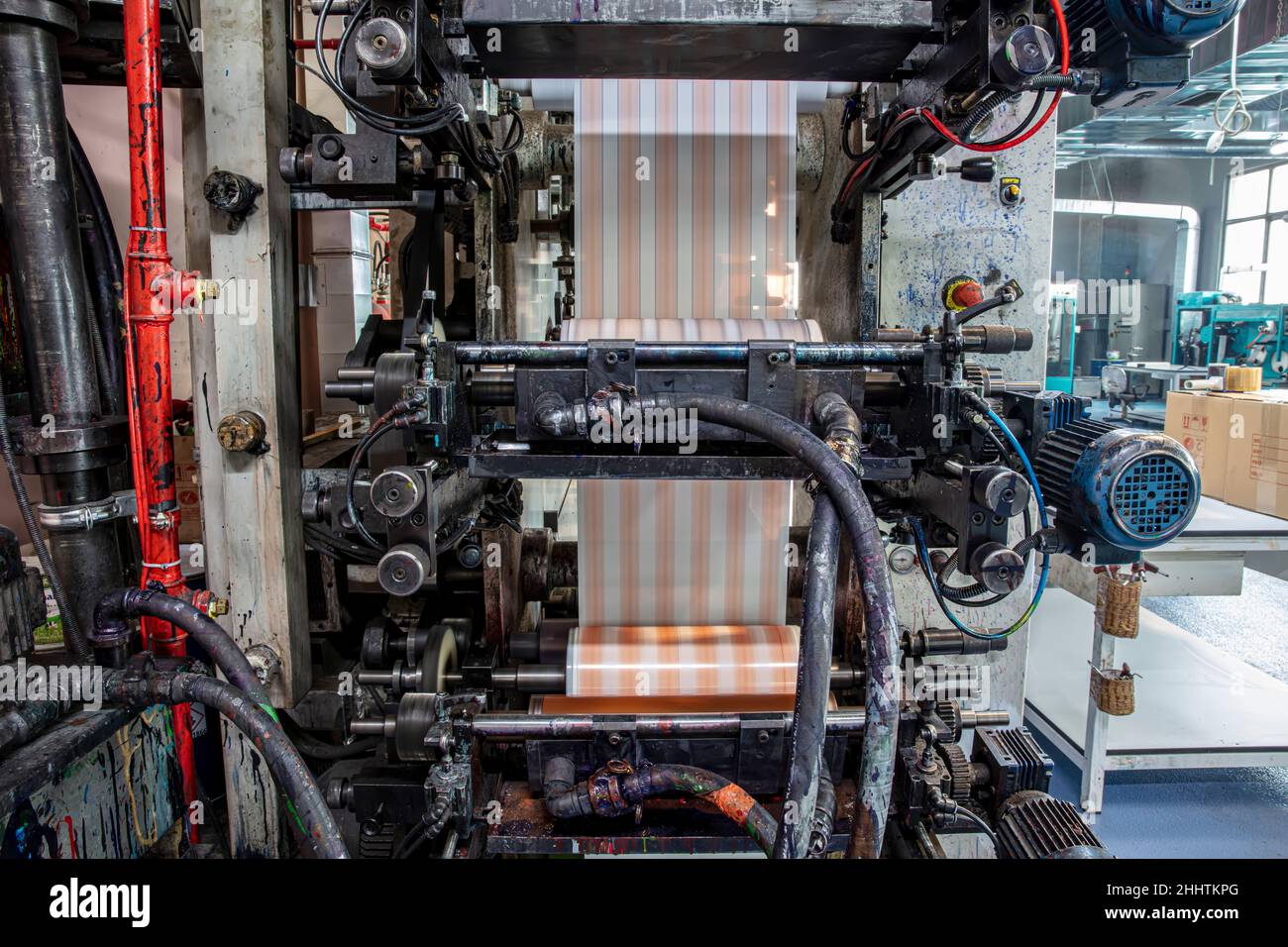 Rotationsstempelschneidemaschine mit Schneidmessersystem. Herstellung von Klebeband.Herstellung von Verpackungsband, CMYCMY in der Druckherstellung. Industrie- und Stockfoto