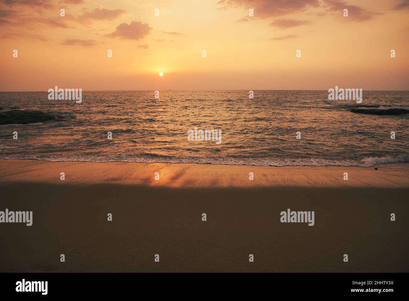 Wunderschöner Sonnenuntergang am Khao Lak Strand in Thailand und man kann die Wellen im Hintergrund sehen, die eine tolle romantische Atmosphäre schaffen. Stockfoto