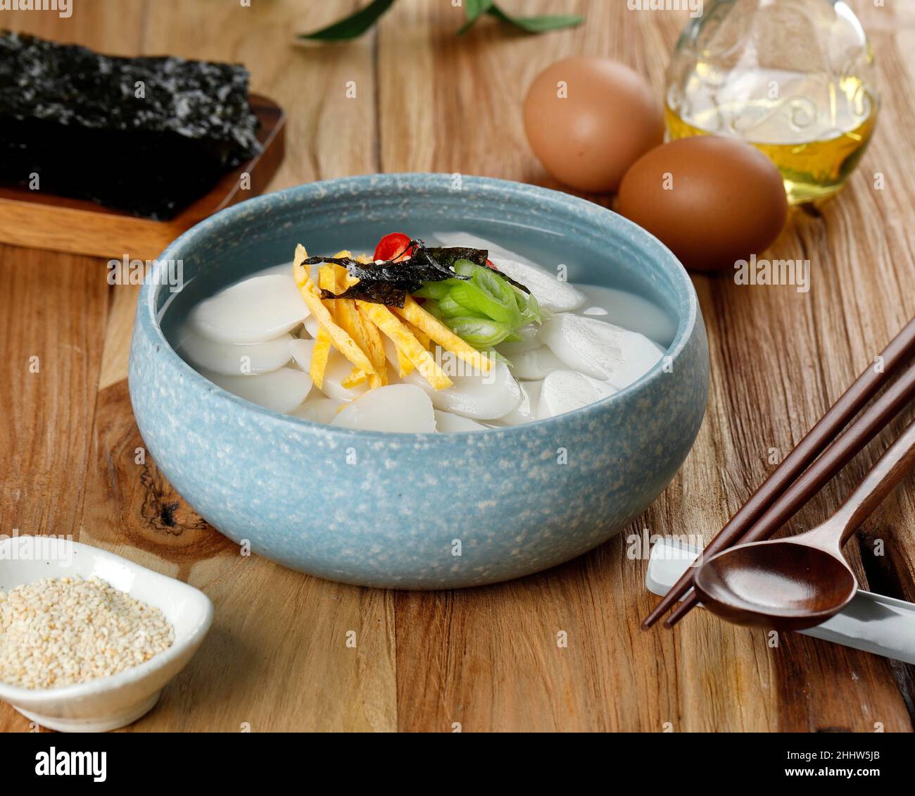 Tteokguk koreanische Reiskonditorei-Suppe für das seelische Neujahr, Topping mit Scheiben Ei, Chili und Sesamsamen Stockfoto